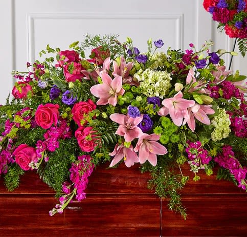 Large pink and purple floral casket spray with lilies and roses