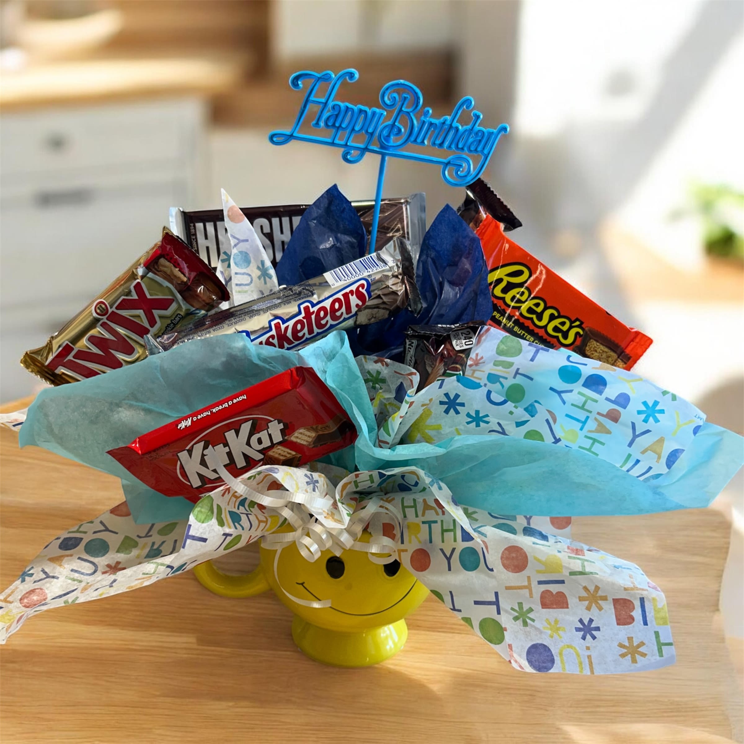 Candy bouquet in a yellow smiley mug with a Happy Birthday topper