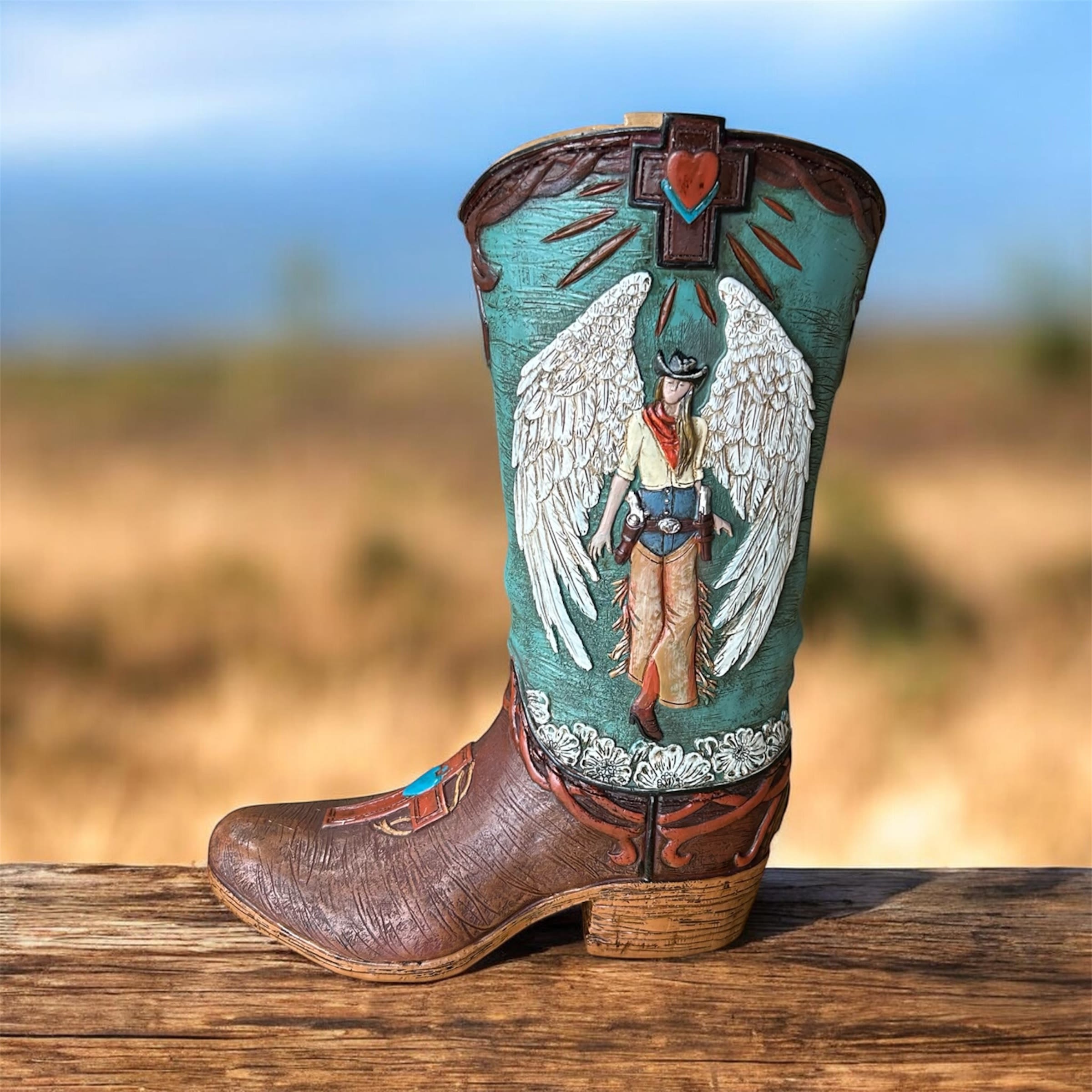 Decorative cowboy boot with an angel figure and cross design