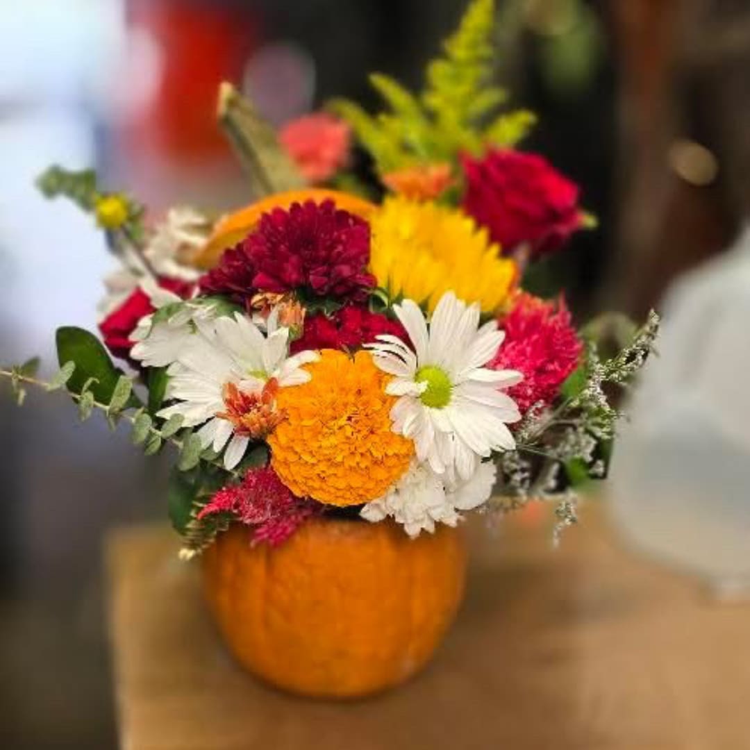Mixed bouquet of colorful flowers in an orange pumpkin container