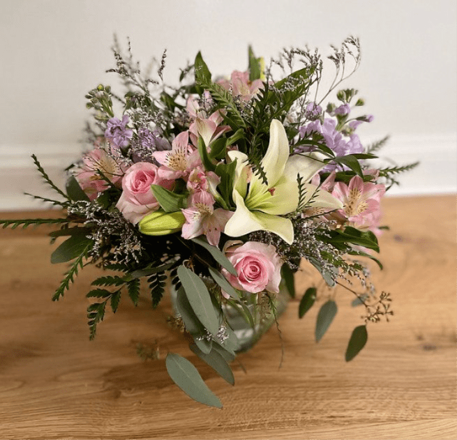 Pink roses and lilies arranged in a glass vase