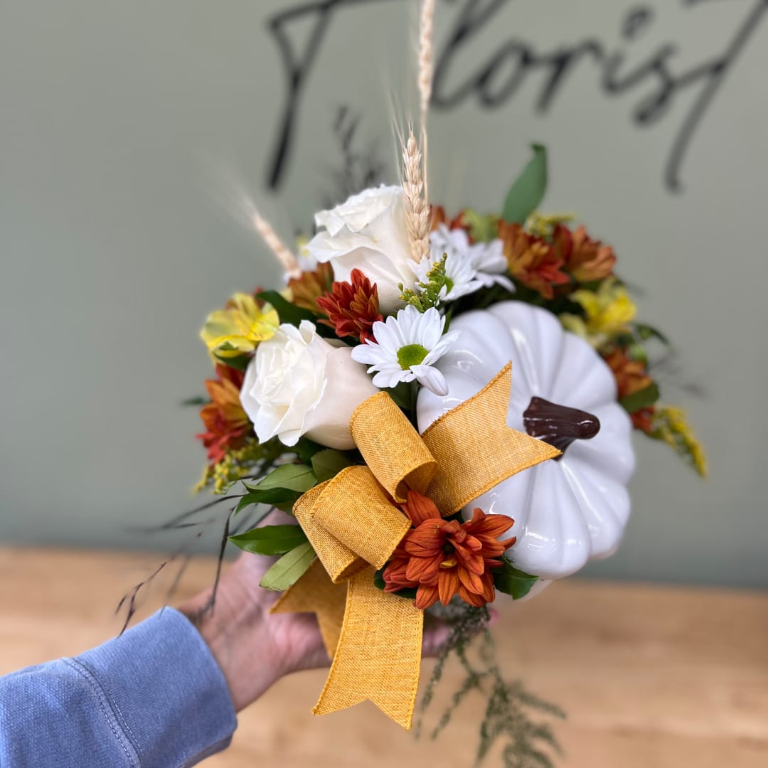 Handheld floral arrangement with white pumpkins, daisies, and orange blooms