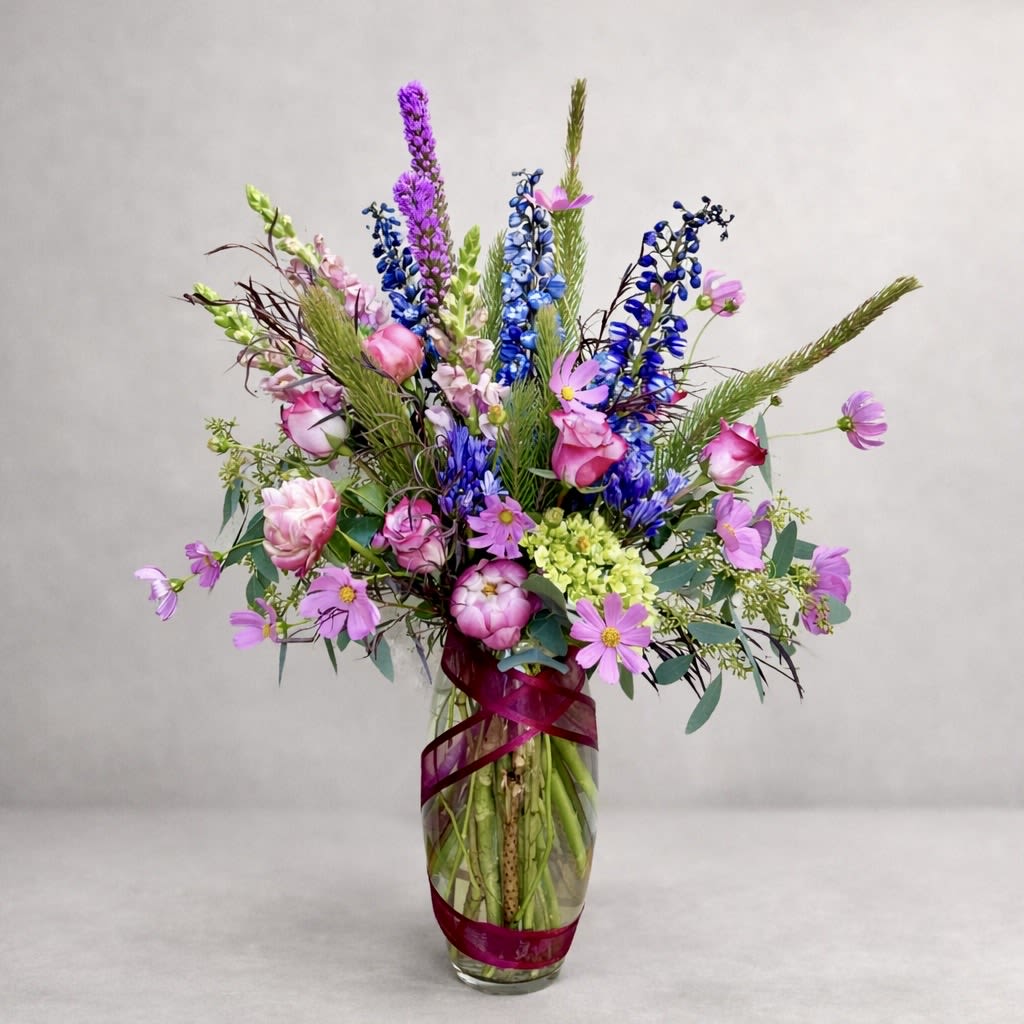Violet Constellation - Violet Constellation is a luminous garden arrangement that feels both intentional and untamed — a composition of saturated blues, radiant pinks, and layered greens gathered in thoughtful balance.  This piece is expressive yet refined, ideal for celebrations, meaningful milestones, or any space that calls for color with presence.