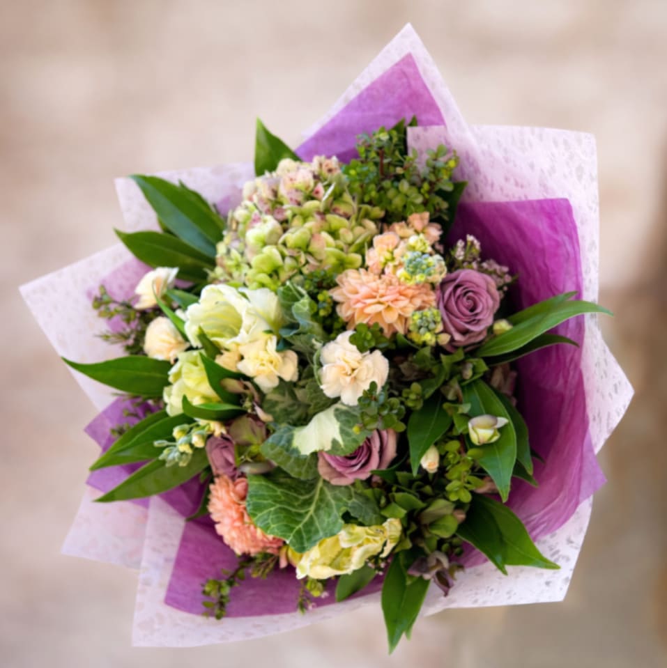 Lavendar Haze - A dreamy and earthy wrapped bouquet with premium antique hydrangea, kale, purple roses, and seasonal peach dahlias.