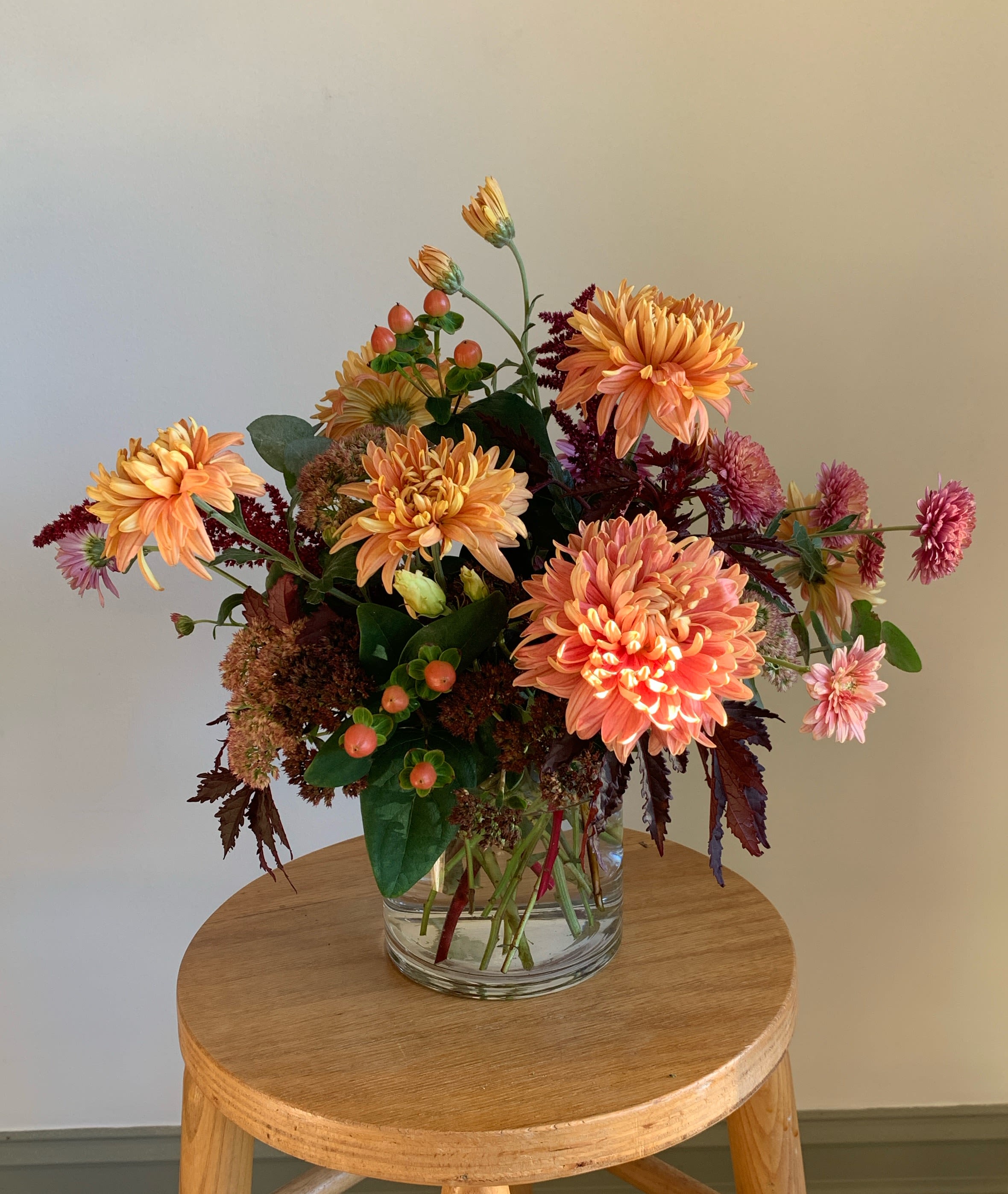 Peach and pink chrysanthemum arrangement in a clear glass vase