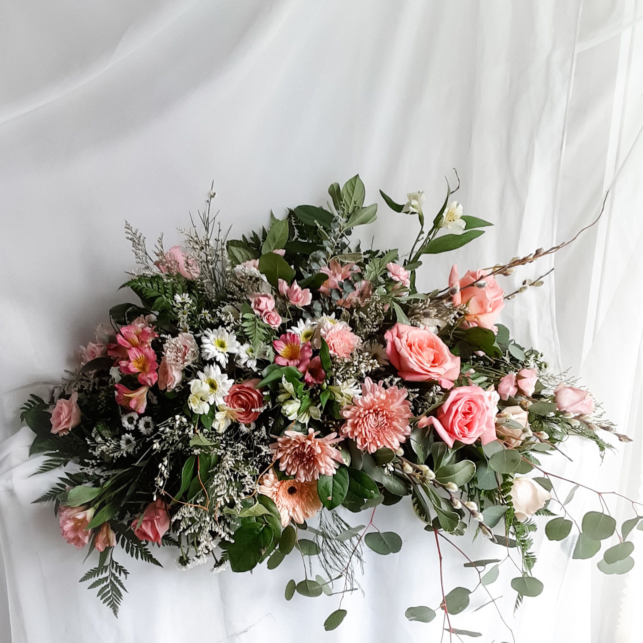 Large pink and white floral arrangement with roses and daisies