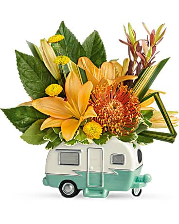 Teleflora's Vintage Vacationer Bouquet - Arranged with a tropical mix of lilies and protea, this delightful ceramic camper transports your very best wishes for a fabulous Father's Day! Orange asiatic lilies, orange pin cushion protea, yellow button spray chrysanthemums, red leucadendron, and variegated pittosporum are arranged with aralia leaf and hala leaf. Delivered in a Retro Road Tripper Camper.