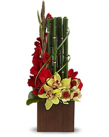 Teleflora's Fantasy Found - If you know someone whose fantasies might include something found on a tropical island, you've found their perfect arrangement. Gorgeous yellow cymbidium orchids and leucadendron, red gladioli, lily grass and other tropical greens are delivered in a distinctive keepsake bamboo cube. This gift's a natural.