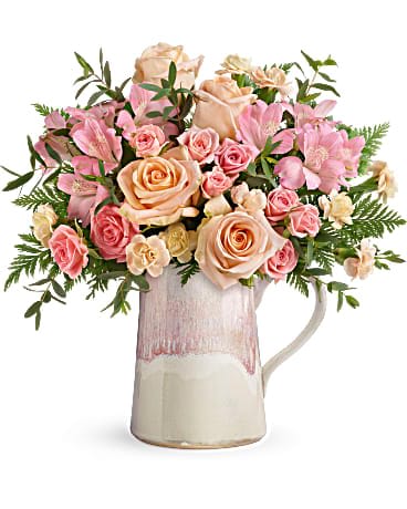 Teleflora's Artisanal Blush Bouquet - Sure to make her blush, this Mother's Day gift is as sweet as they come! Nothing's prettier than a delicate bouquet of pink and peach roses, presented to perfection in this artisanal ceramic pitcher with gorgeous, iridescent reactive glaze. This beautiful bouquet includes peach roses, pink spray roses, pink alstroemeria, miniature peach carnations, parvifolia eucalyptus, and leatherleaf fern. Delivered in a Heart Stone pitcher.