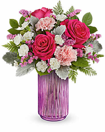 Teleflora's Pink Glow Bouquet - Celebrate the beauty of spring with this enchanting floral arrangement, featuring a delightful array of pink and white flowers, beautifully presented in a radiant pink lantern. This Pink Glow bouquet features an enchanting mix of hot pink roses, pink carnations, miniature white carnations, and raspberry statice. This vibrant arrangement is beautifully complemented by dusty miller, leatherleaf fern, and lemon leaf. It is delivered in a Radiant Joy lantern.