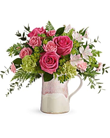 Teleflora's Heart Stone Bouquet - Make their heart flutter with an extra special delivery! Hot pink roses and fresh greens look oh-so-chic in this stylish stoneware pitcher, featuring an iridescent reactive glaze in the prettiest shade of pink. It's food-safe for years of enjoyment! Hot pink roses, pink spray roses, light pink alstroemeria, green carnations and pink miniature carnations are arranged with bupleurum, leatherleaf fern, and parvifolia eucalyptus. Delivered in a Heart Stone pitcher.