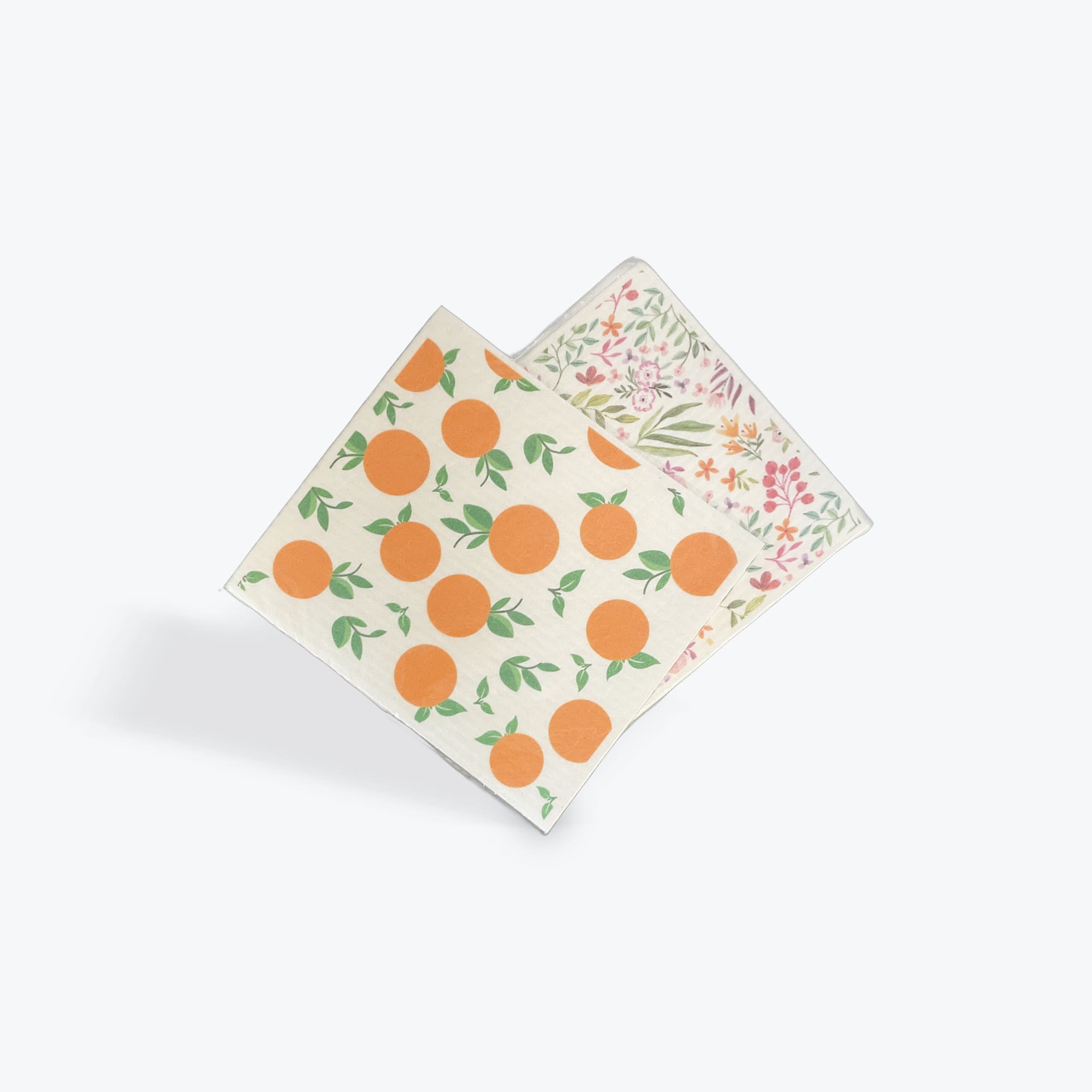 Two patterned square napkins with orange fruit and floral prints