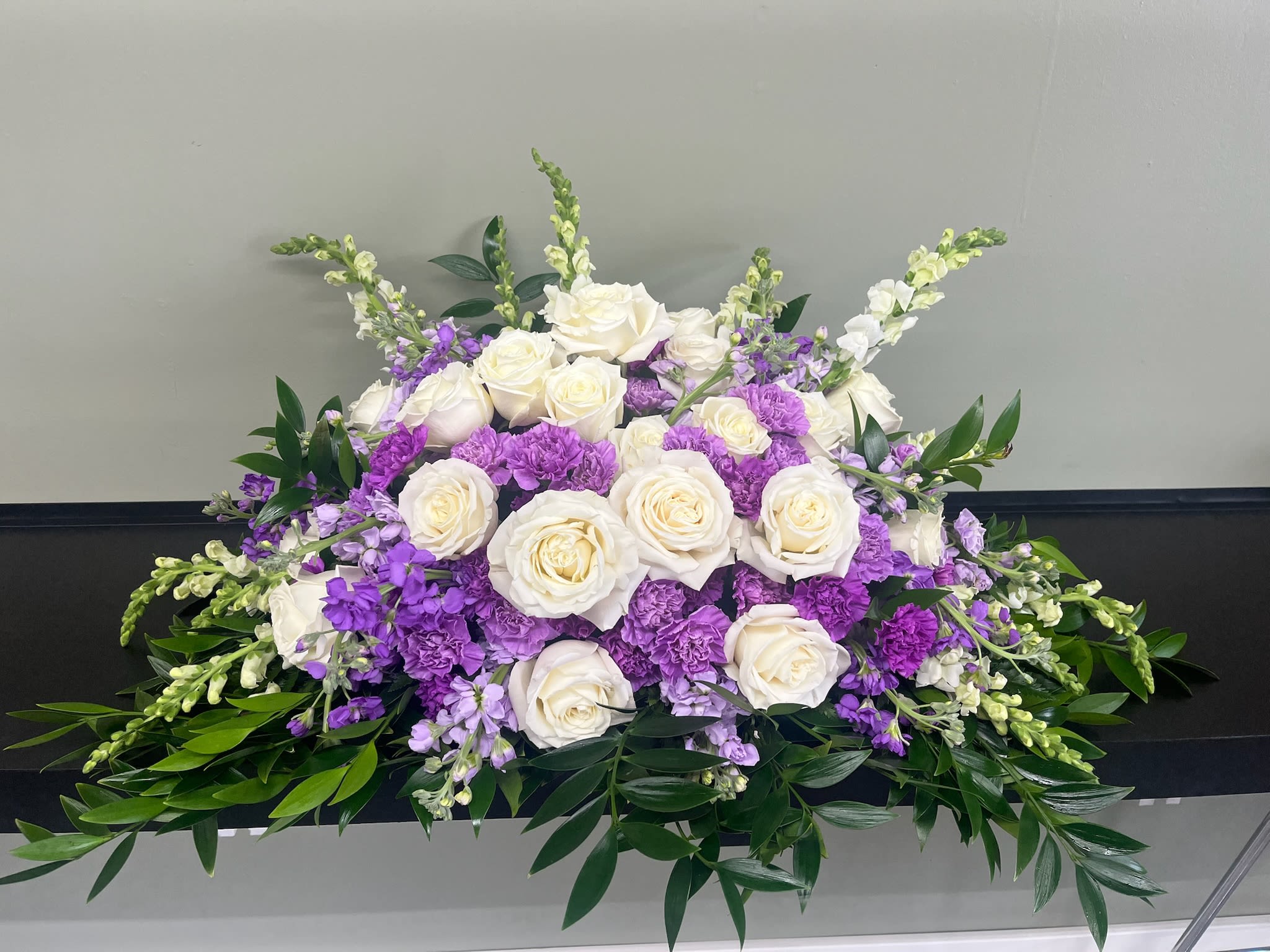 White roses and purple flowers arranged in a low centerpiece