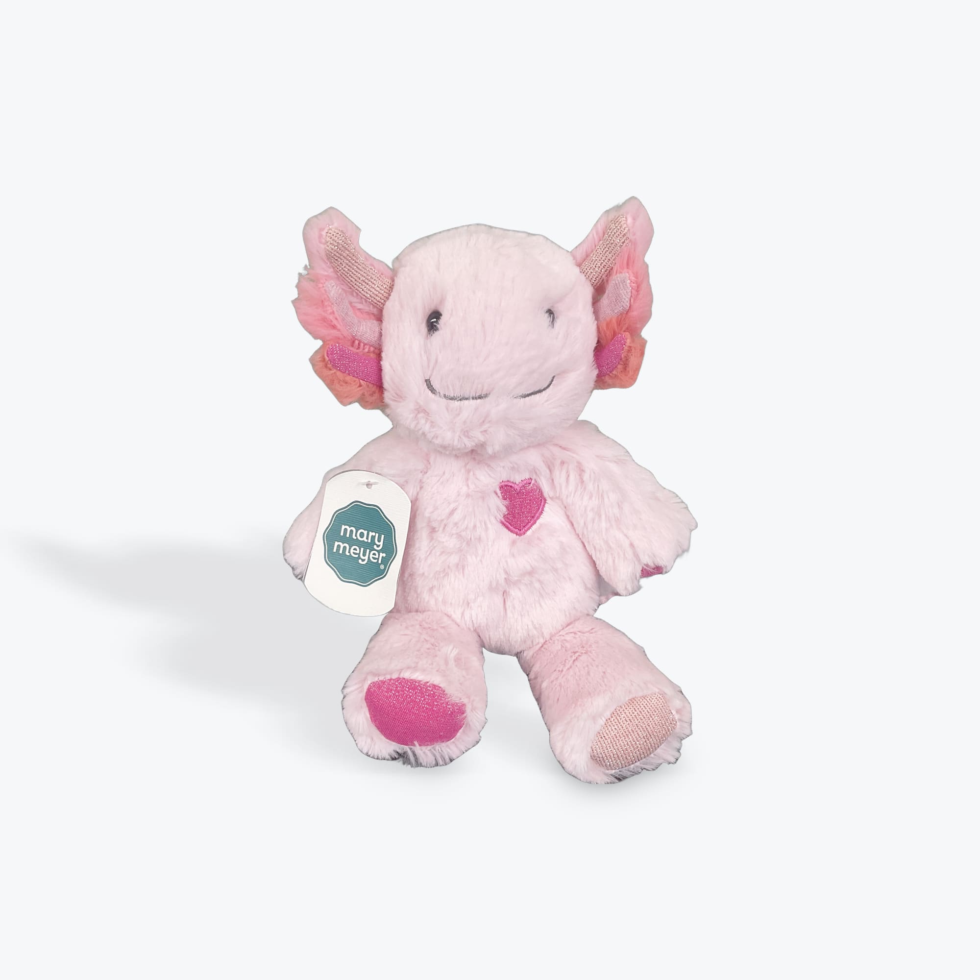 Pink plush stuffed animal with butterfly-like ears and a heart on its chest