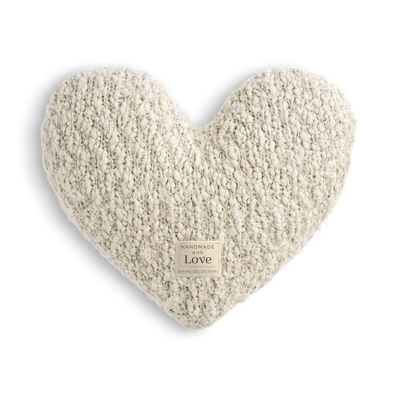 Heart-shaped knitted pillow in cream with a small label