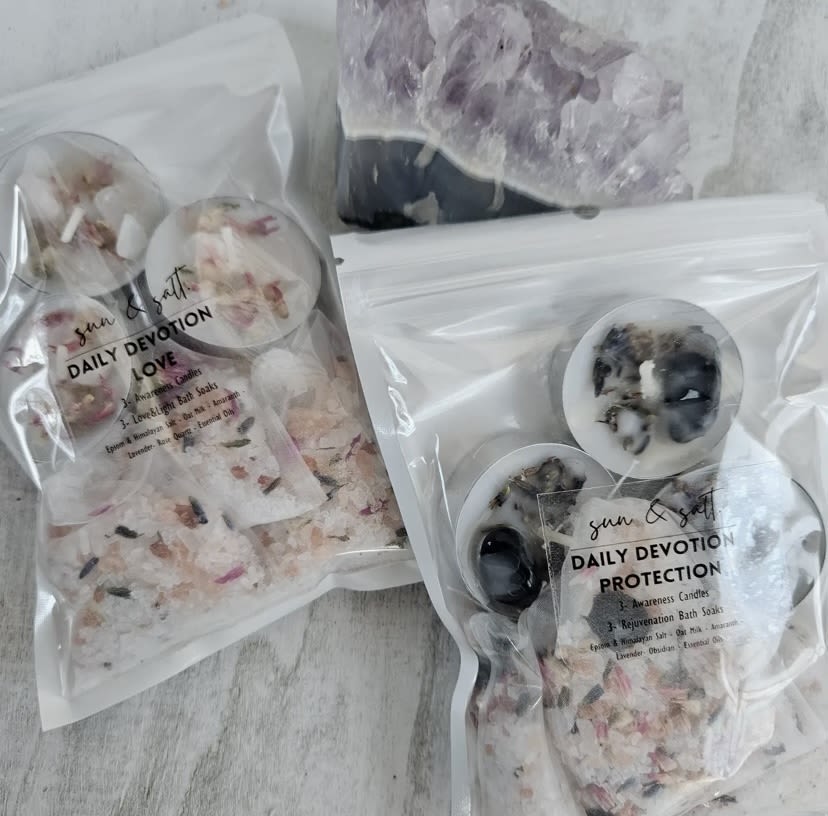 Assorted packaged candles with dried flower pieces and crystal accents
