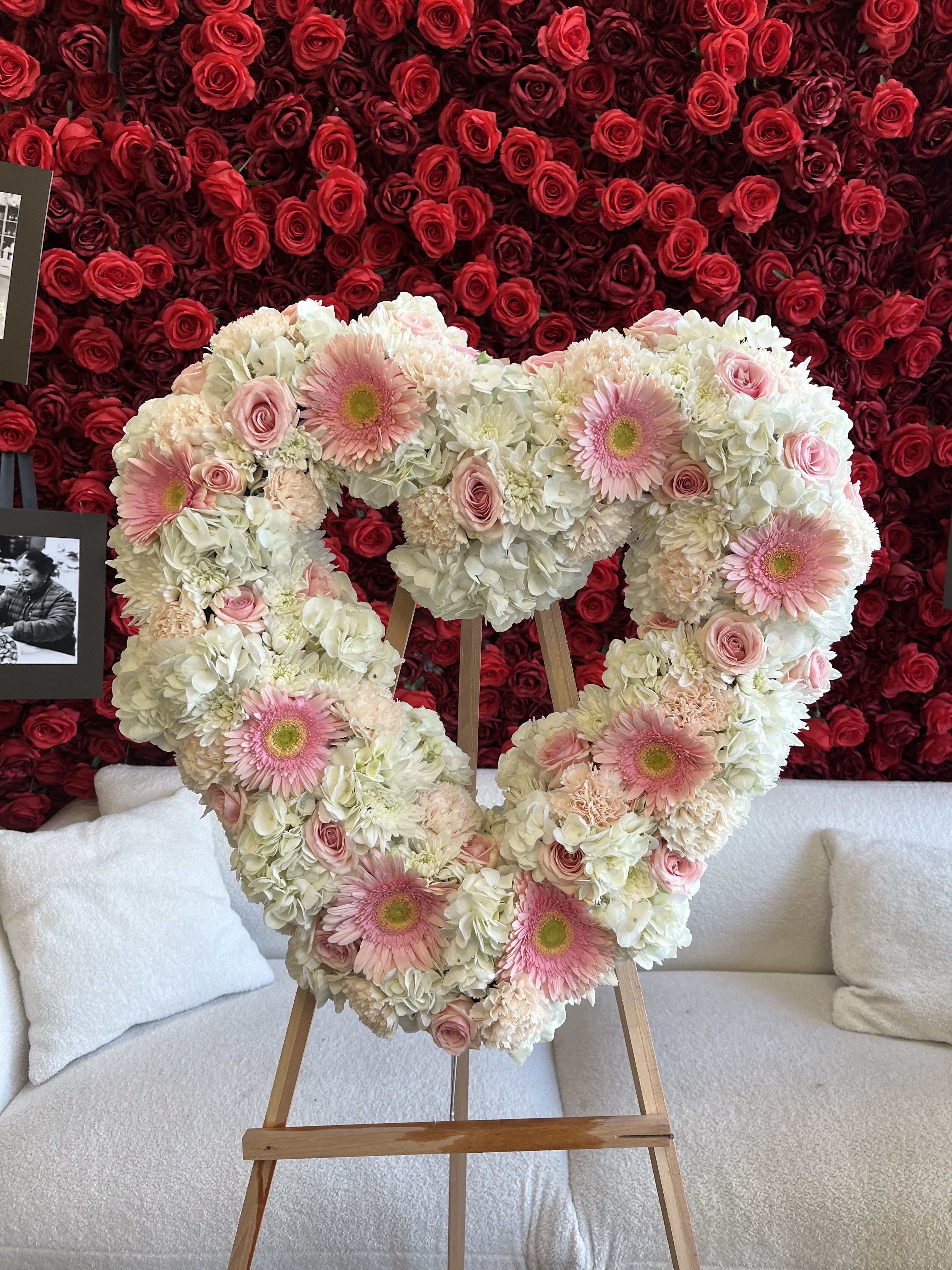 Heart-shaped floral arrangement with pink gerberas, roses, and white hydrangeas