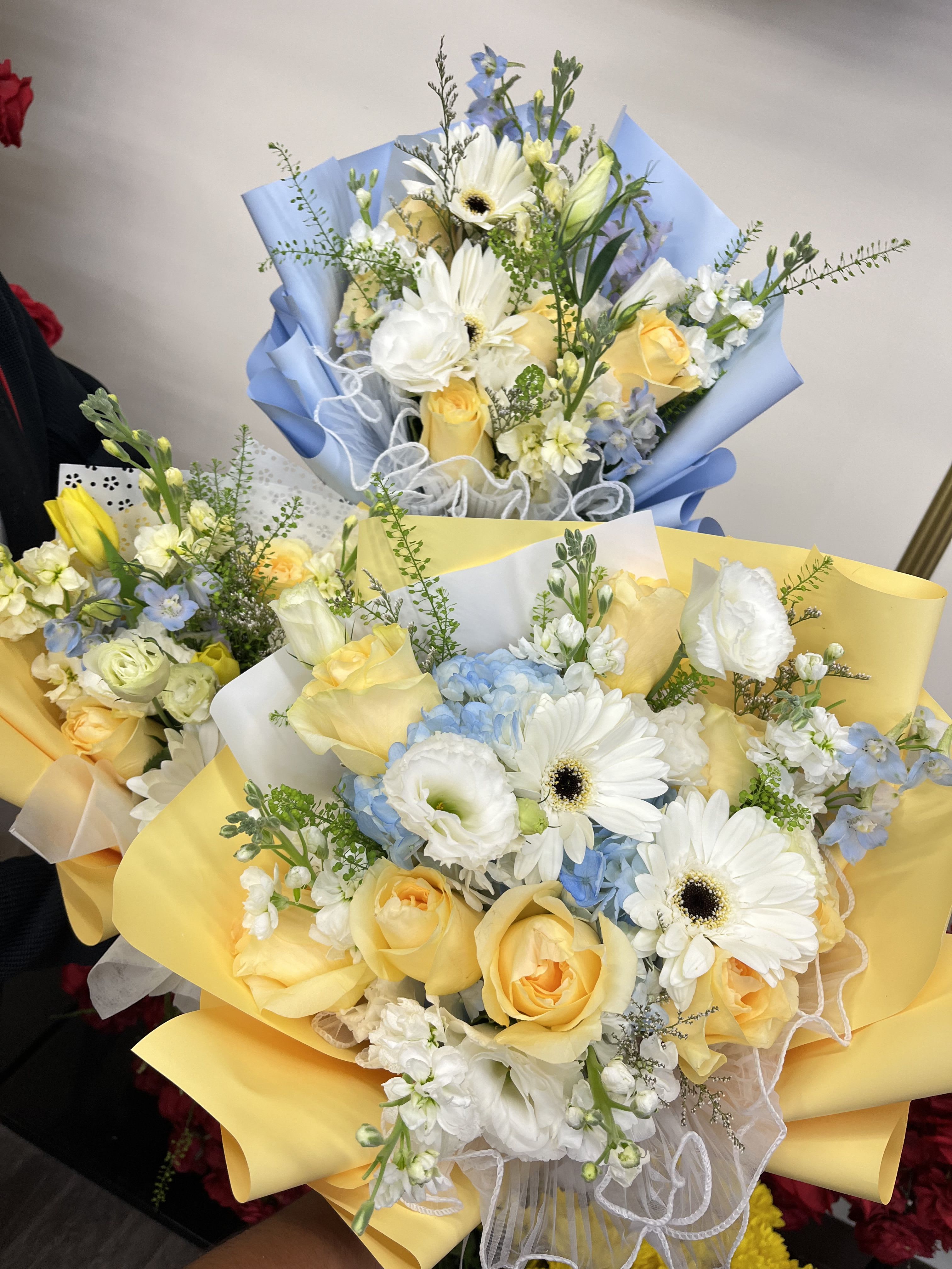 Florist Choice- Yellow &amp; Blue Wrapped bqt - A bright and refreshing hand-wrapped bouquet designed with a seasonal mix of yellow and blue blooms. Each arrangement is florist’s choice, meaning we select the freshest flowers available to create a balanced, vibrant look. Wrapped in our signature style, this bouquet is perfect for birthdays, celebrations, or simply to brighten someone’s day. Flower varieties may vary, but the color palette will remain true to yellow and blue tones.