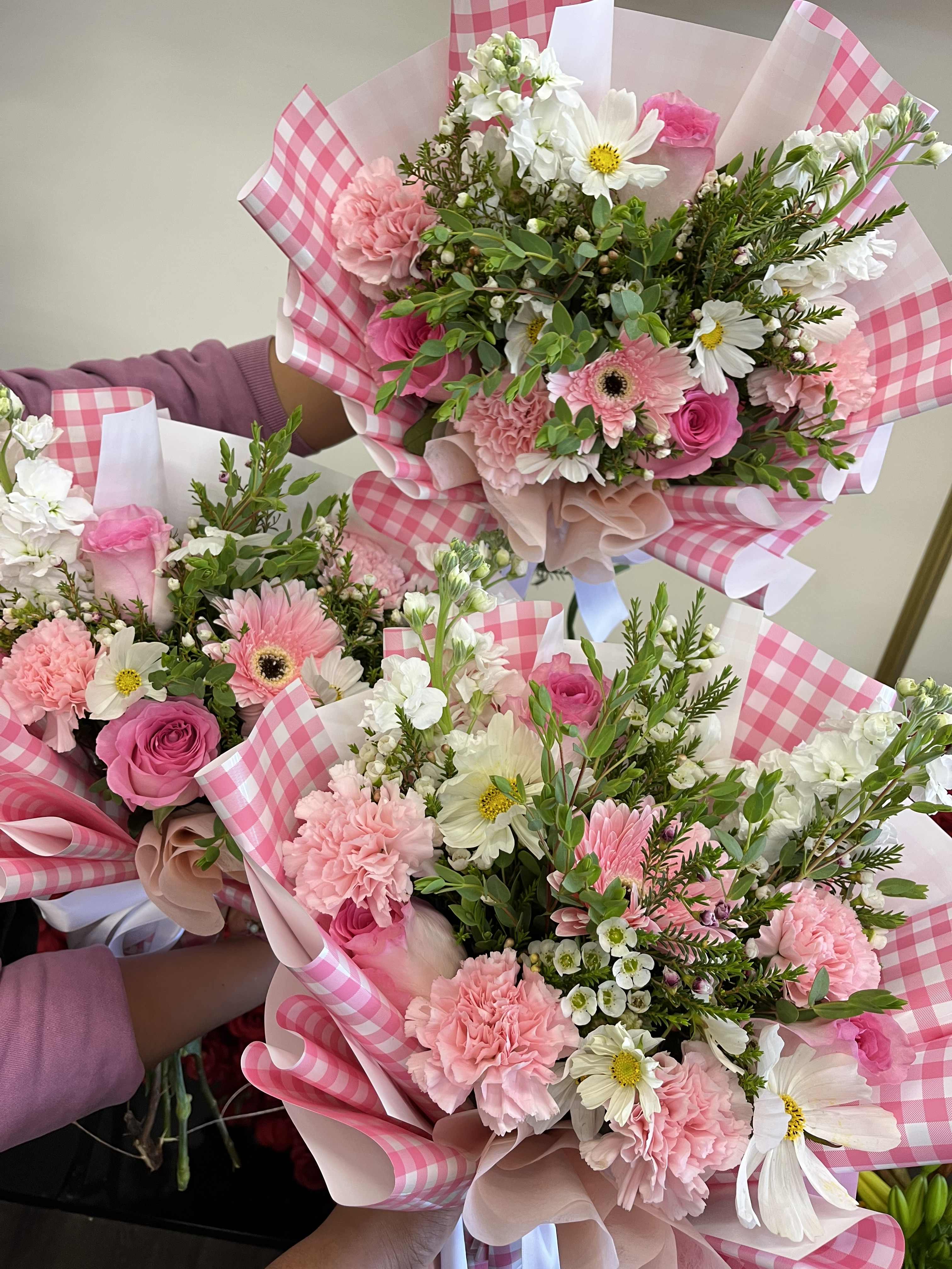 Pink and white mixed bouquets wrapped in pink gingham paper