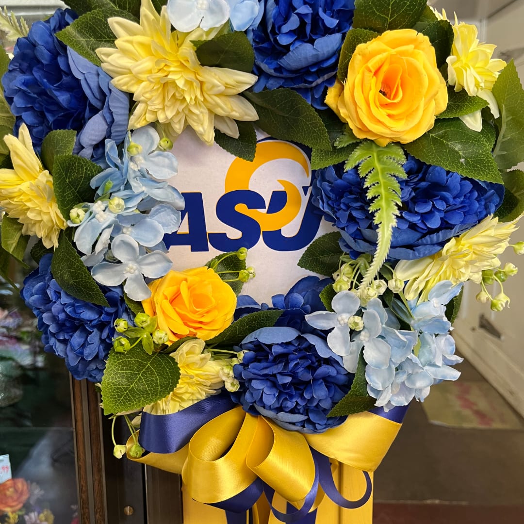 Blue and yellow floral wreath with a ribbon bow and ASU logo center
