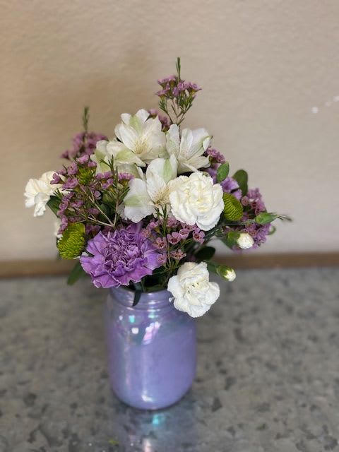 Purple and white bouquet in a lavender vase