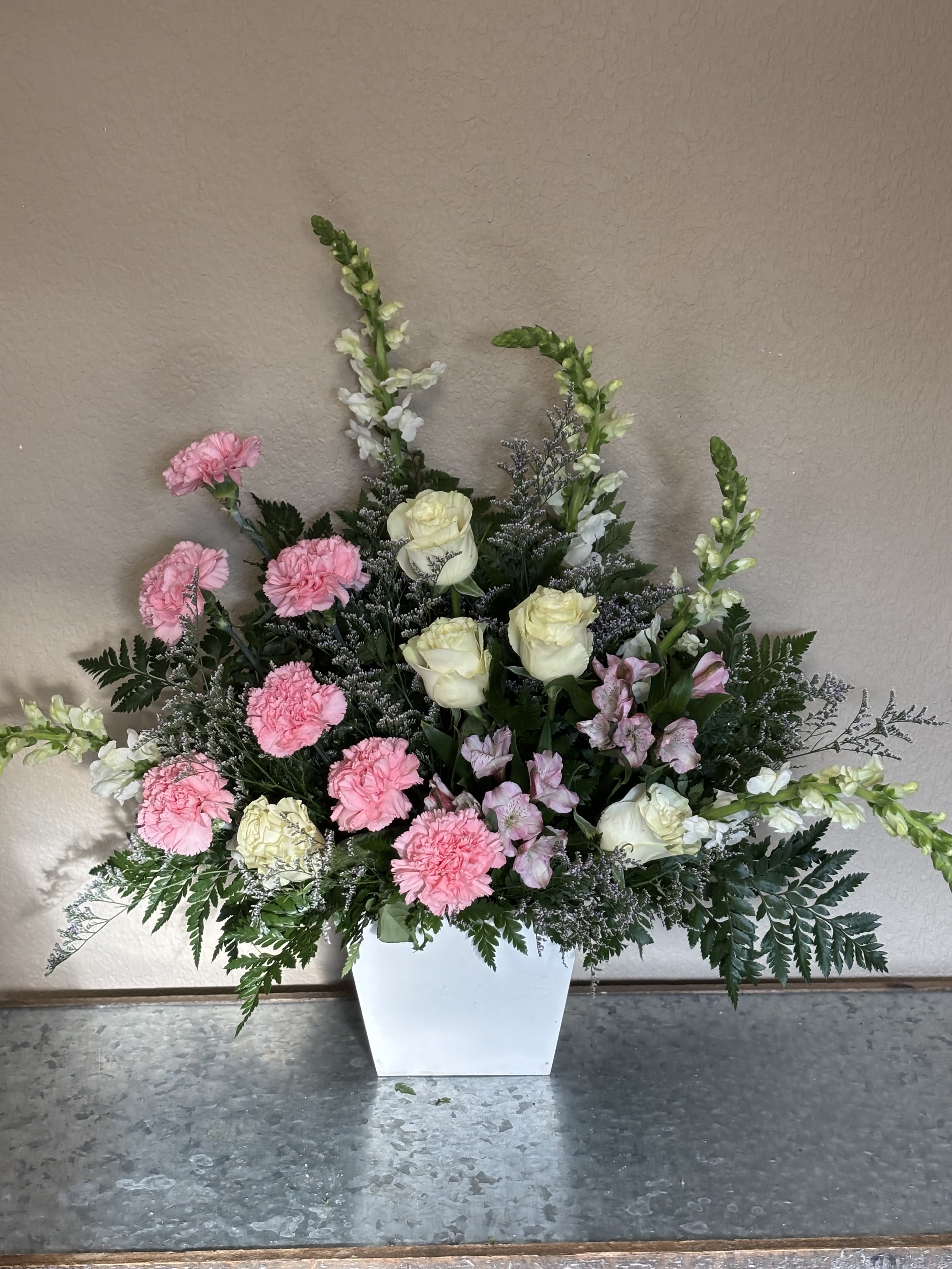 Pink carnations and white roses in a white vase
