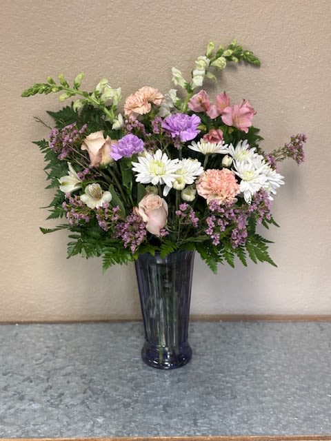 Mixed pastel bouquet in a tall dark vase