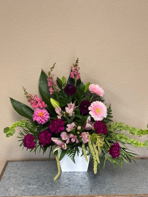 Pink and purple floral arrangement in a white vase