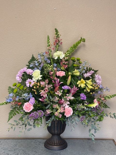 Large mixed floral arrangement in a dark urn vase
