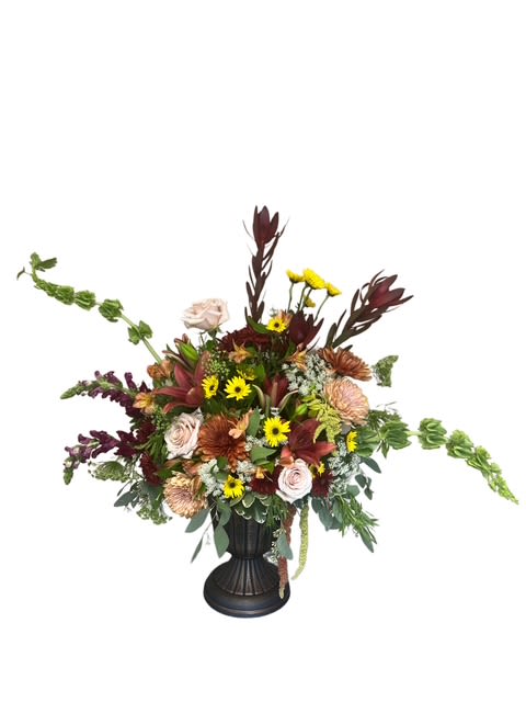 Large mixed flower arrangement in a black vase with burgundy and yellow blooms