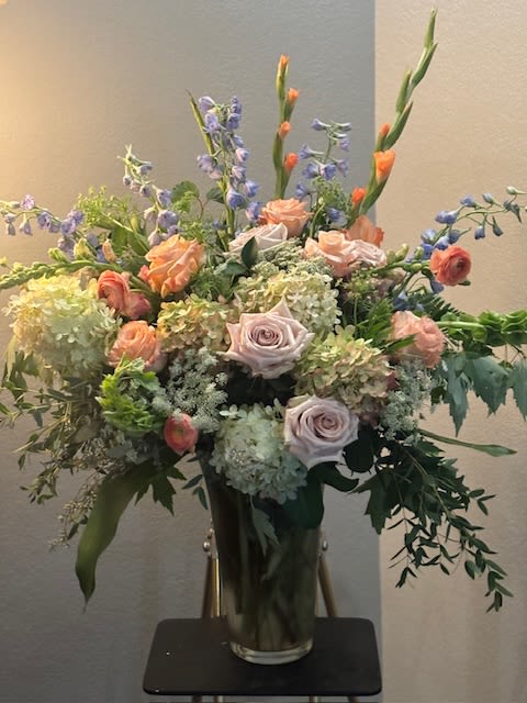 Tall mixed bouquet in a glass vase with lavender and peach flowers