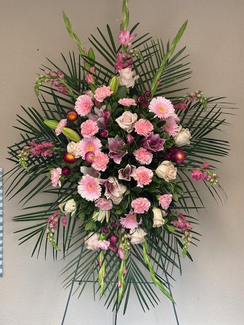 Large pink and white funeral spray with palm fronds