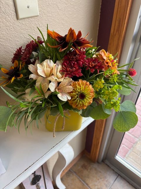 Mixed bouquet of chrysanthemums and alstroemeria in a yellow container