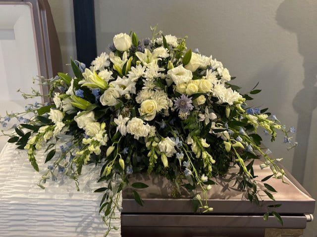 Large white floral spray on a casket