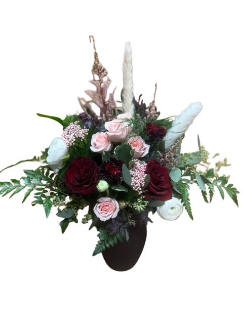 Mixed bouquet with red and pale pink roses in a dark vase
