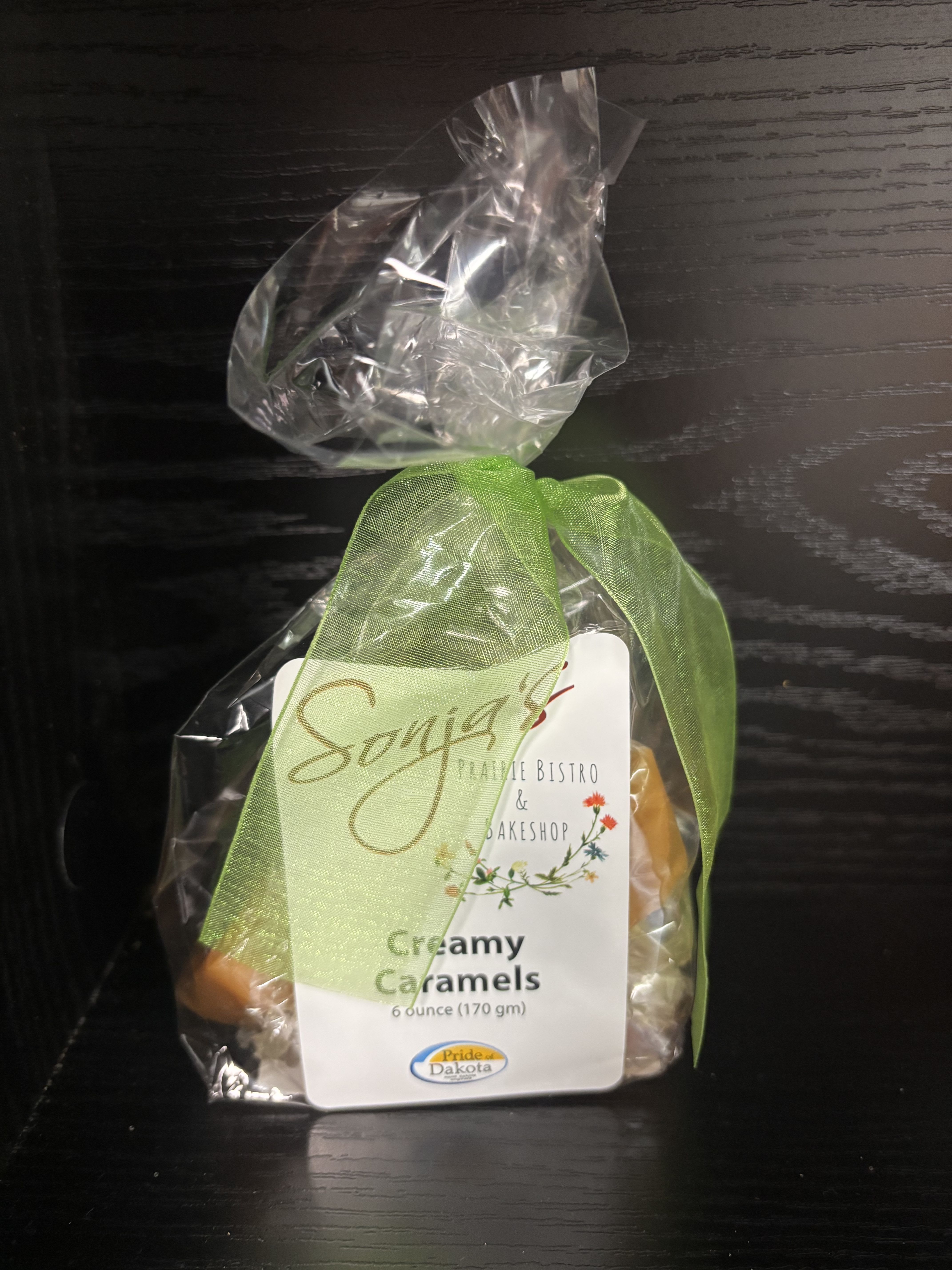 Bag of creamy caramels tied with a green ribbon