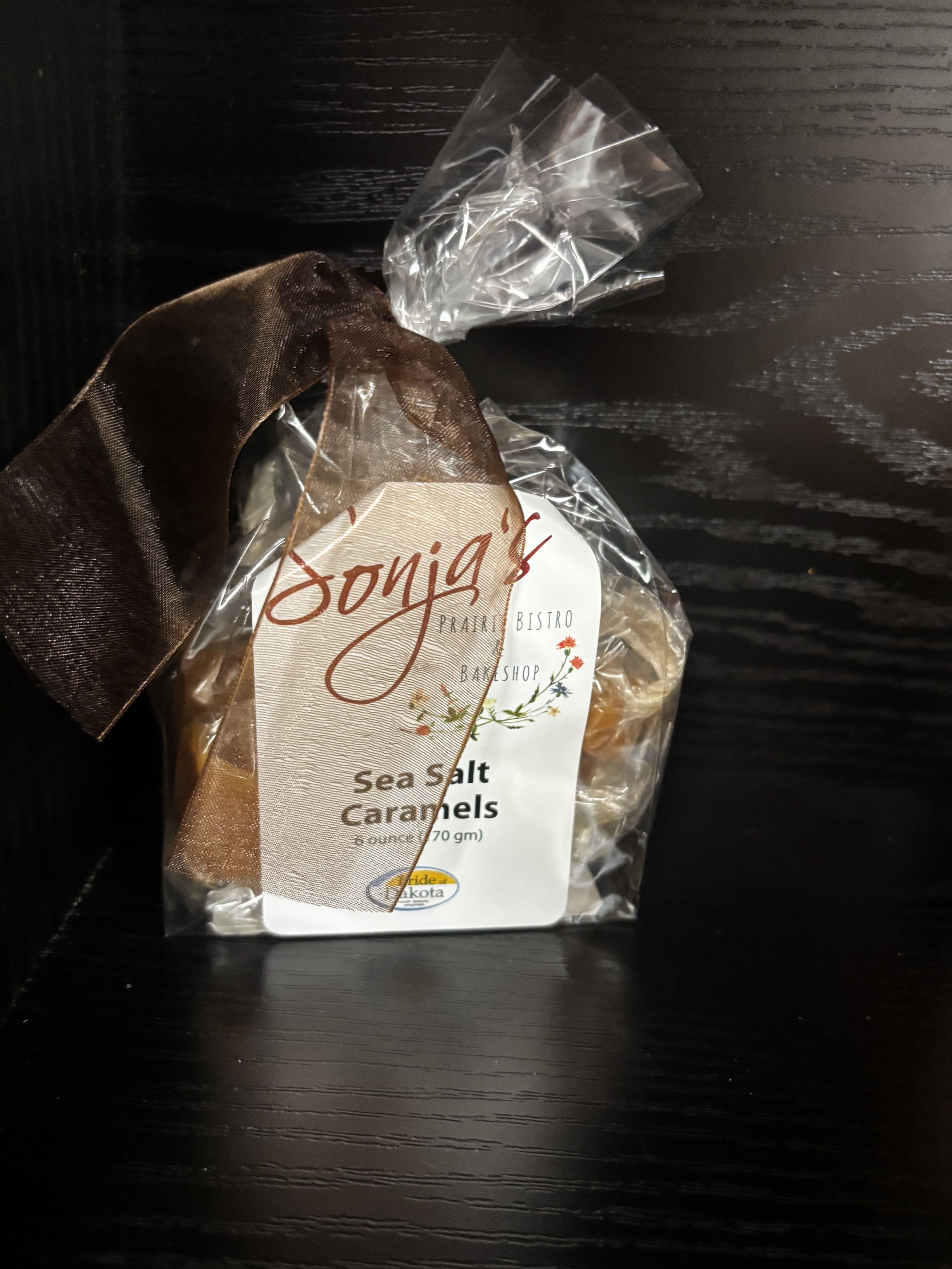 Wrapped bag of sea salt caramels with a brown ribbon