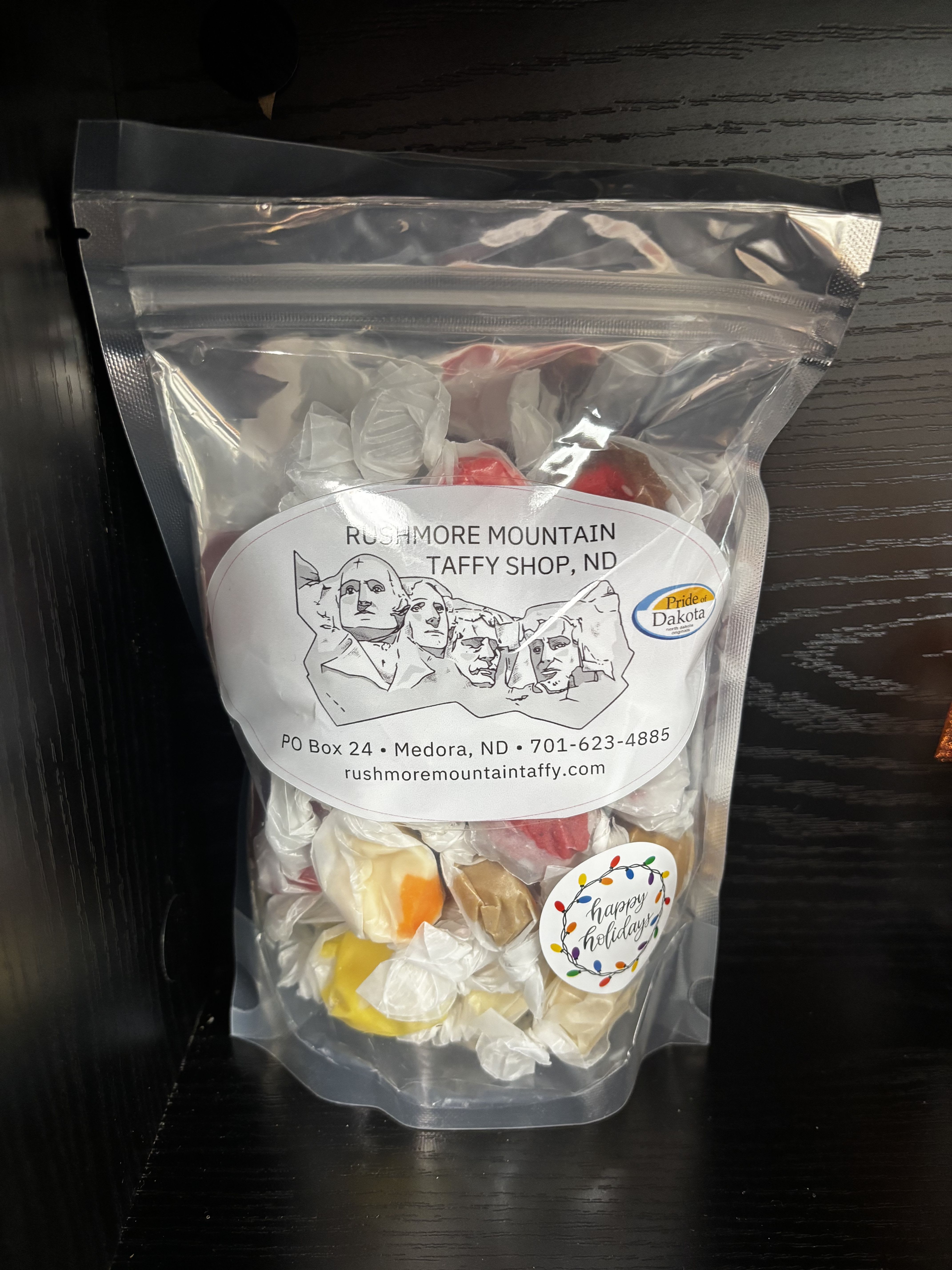Clear bag of assorted wrapped taffy candies with holiday label