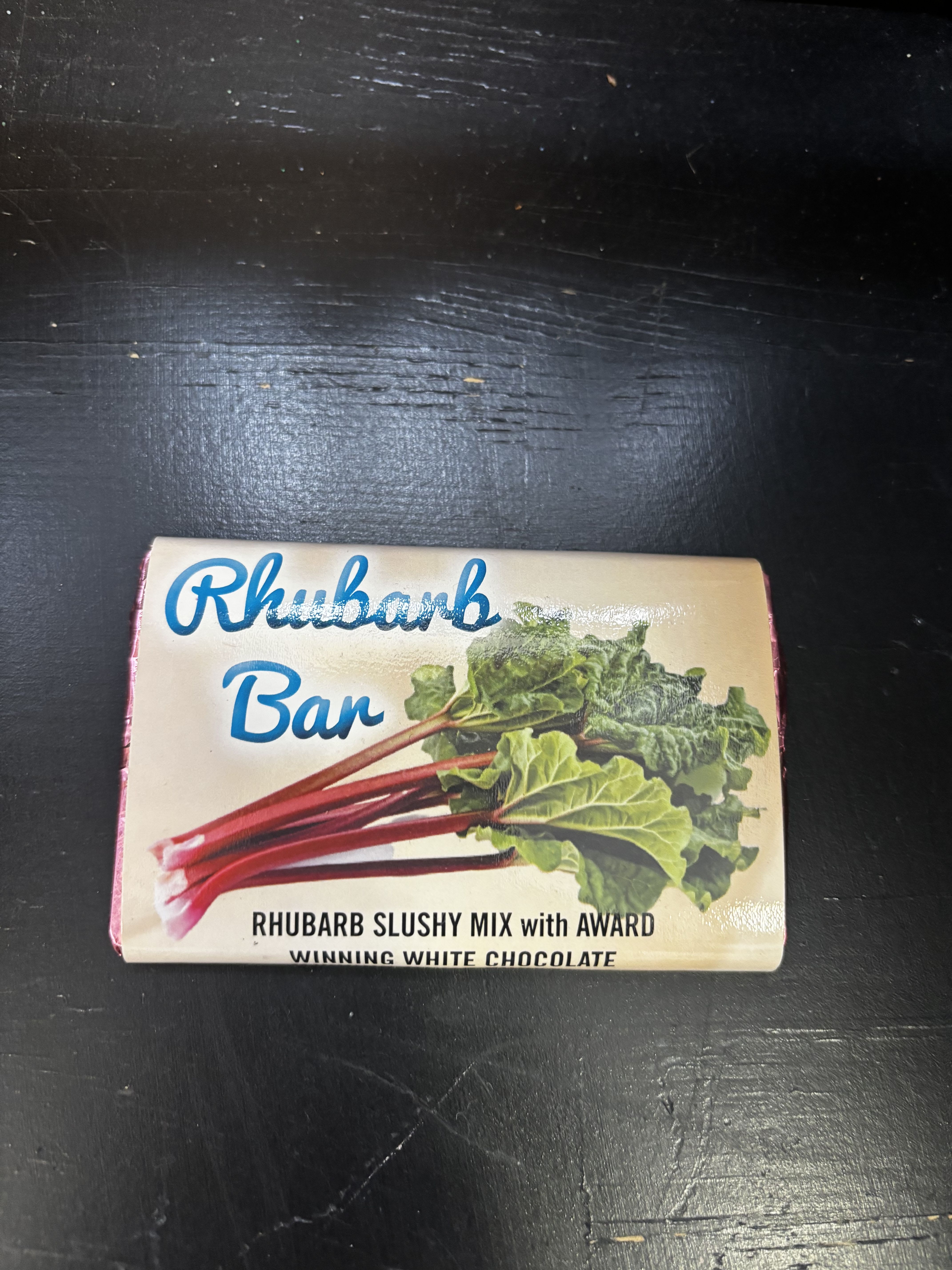Box of Rhubarb Bar chocolate on a dark surface