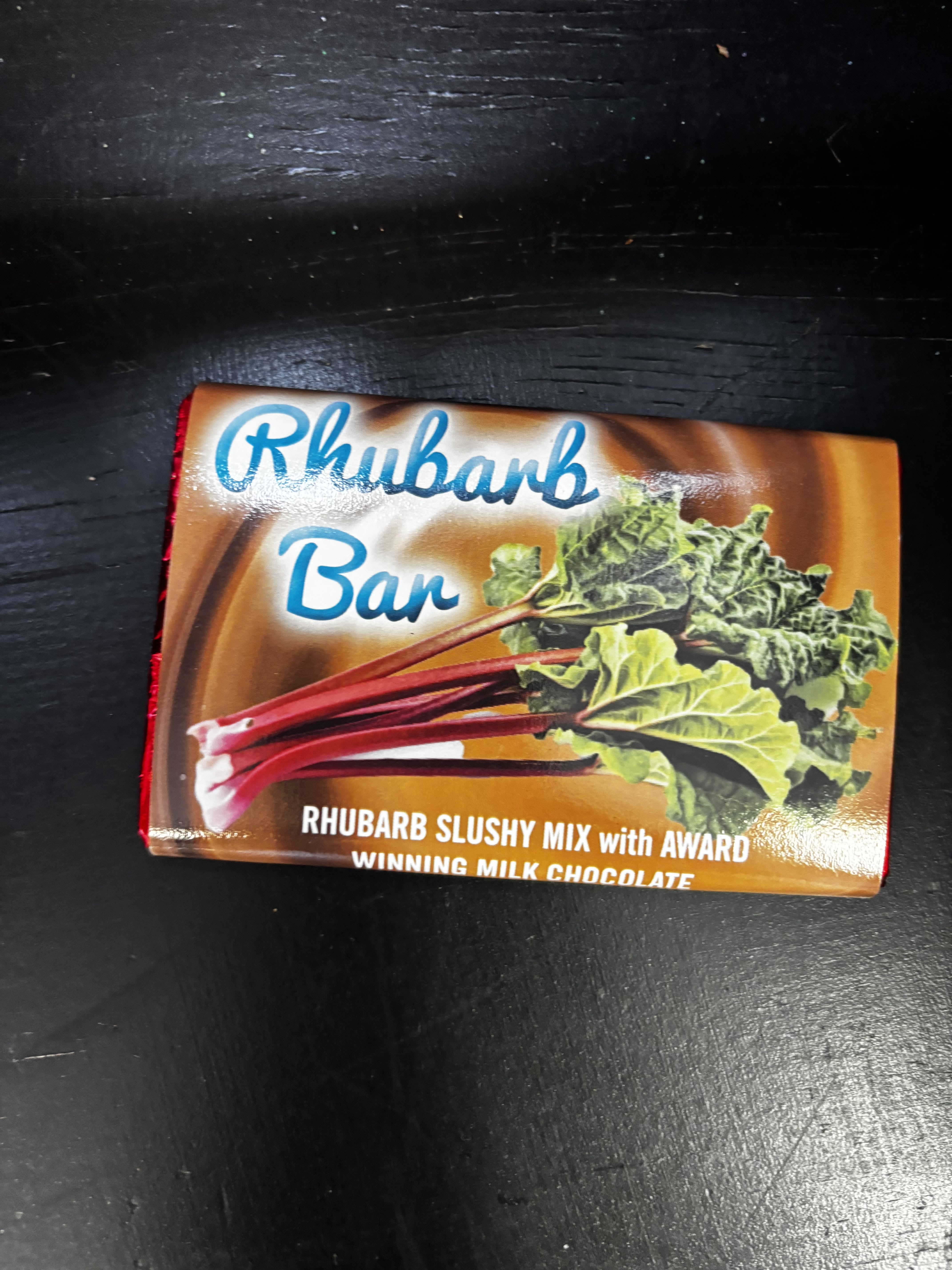 A Rhubarb Bar chocolate package on a dark surface