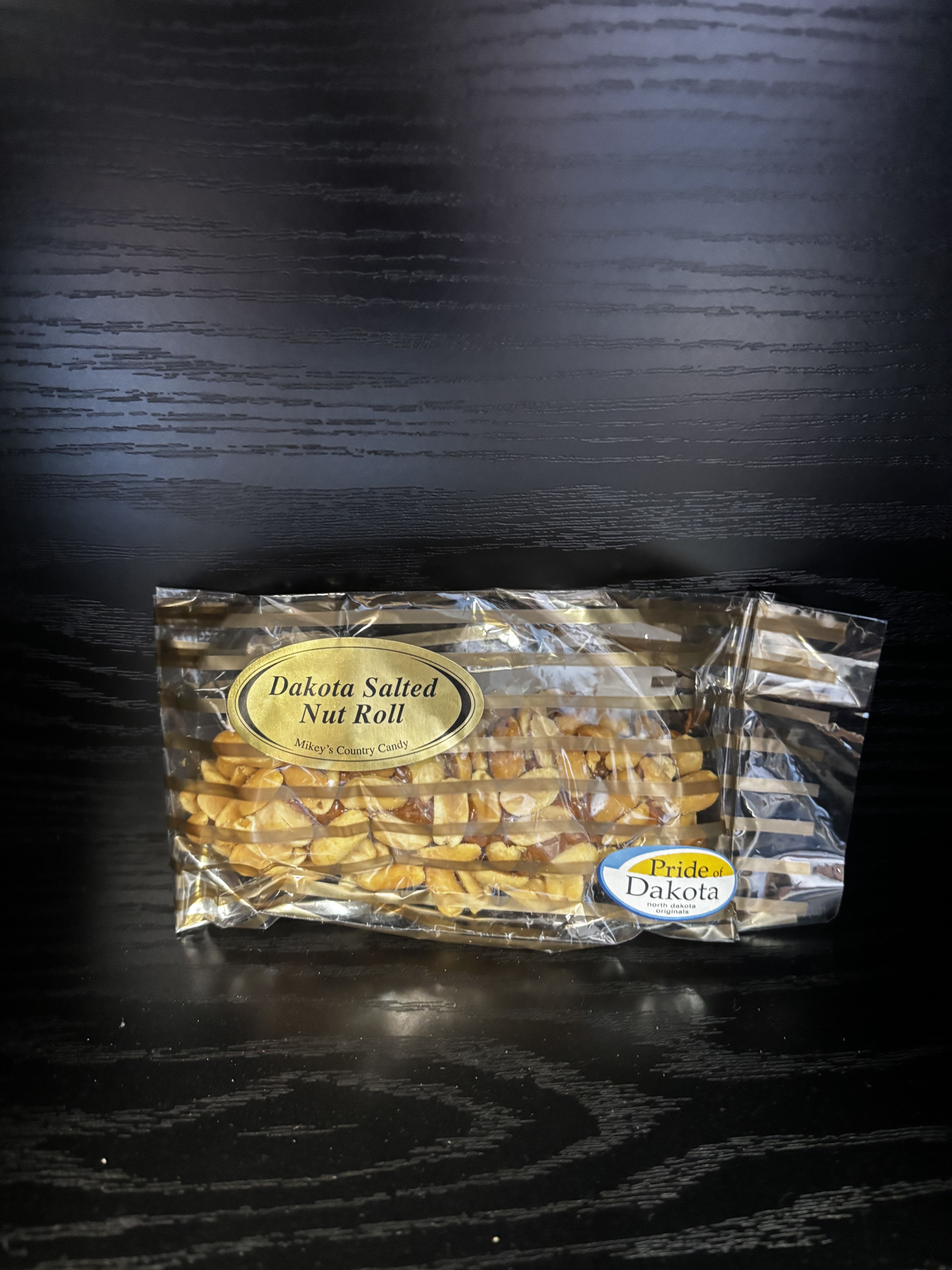 Bag of Dakota Salted Nut Roll candy on a dark surface