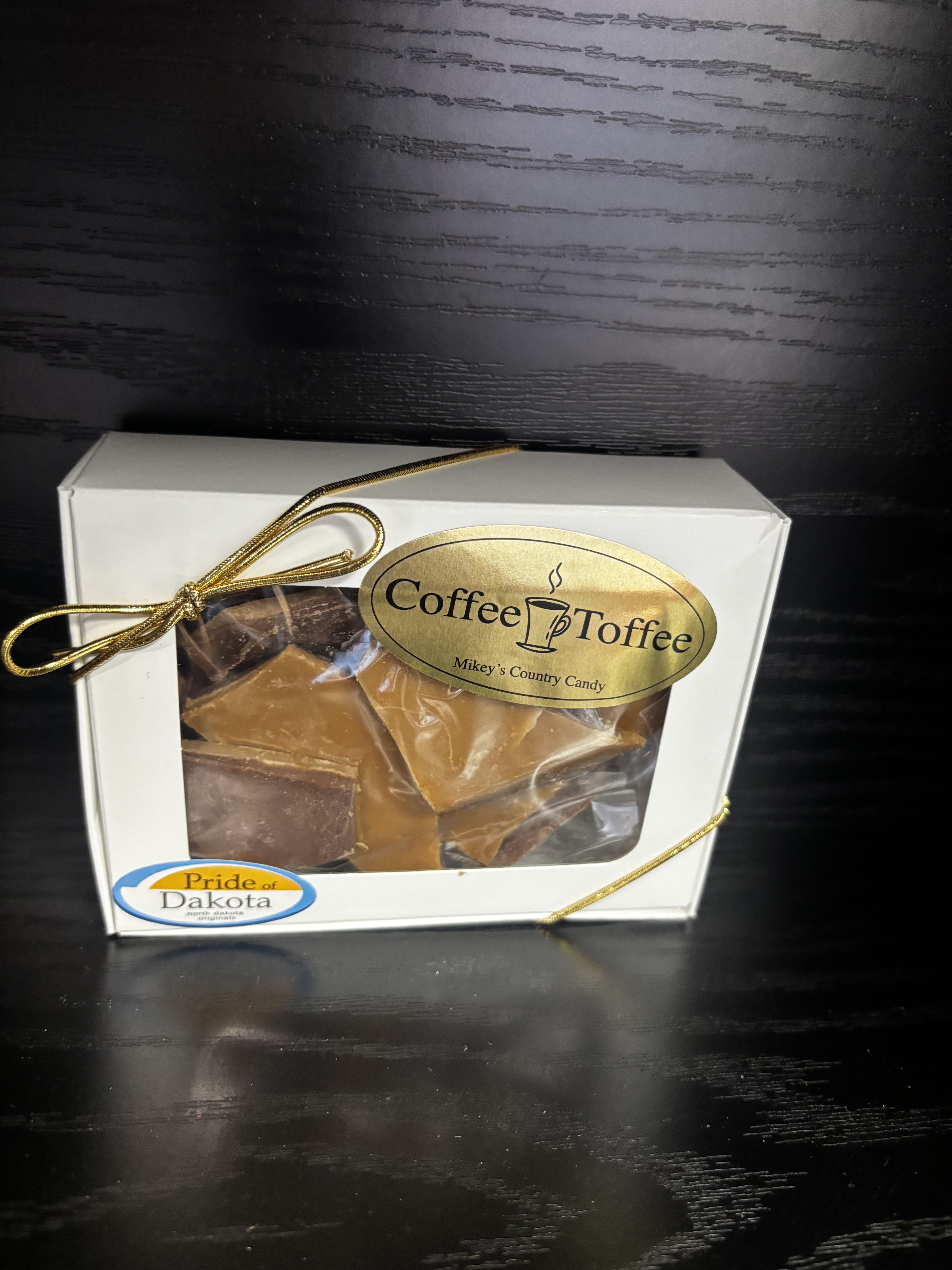 Box of coffee toffee candy tied with a gold ribbon