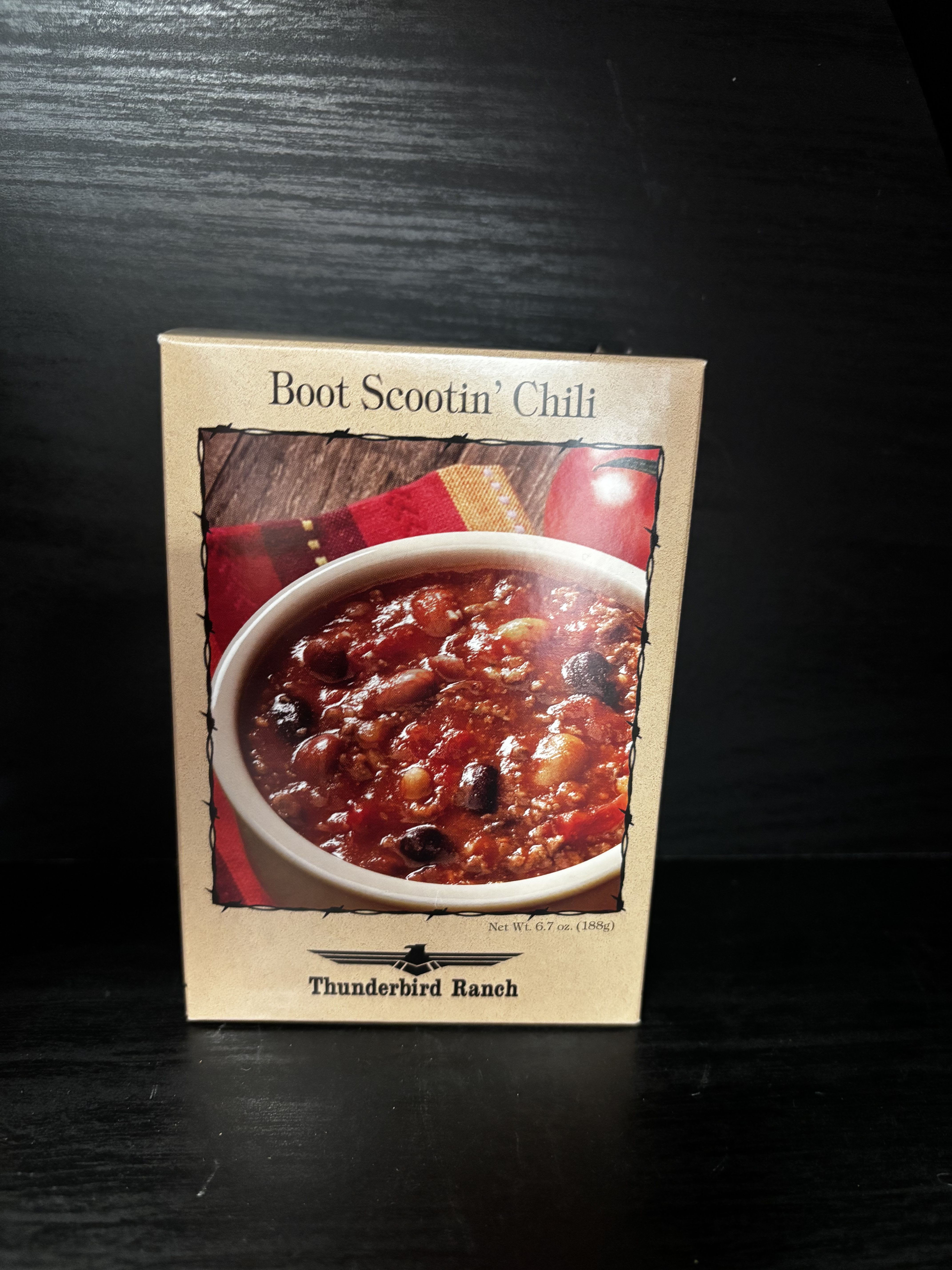 Box of Boot Scootin' Chili mix on a dark surface