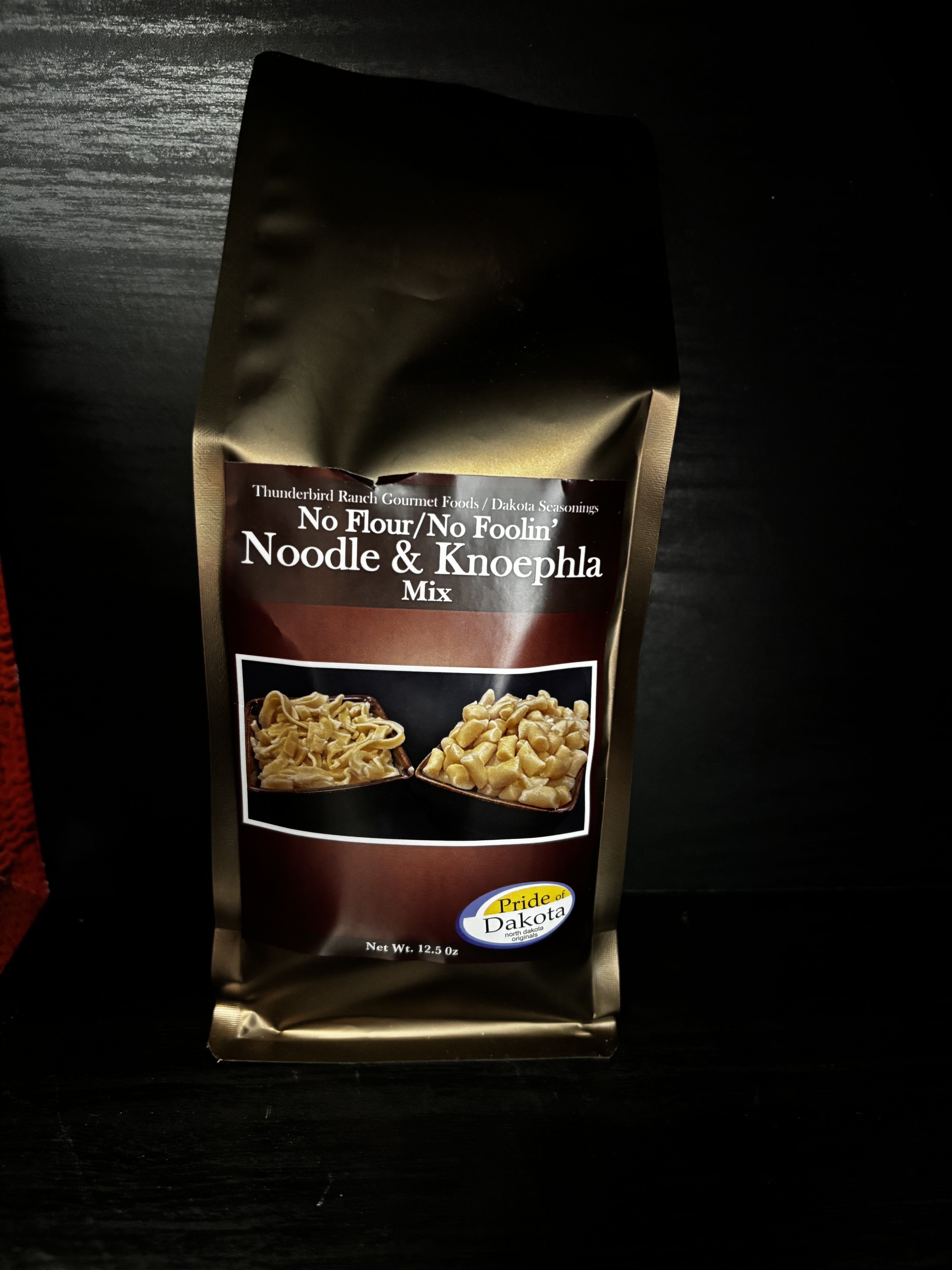 Bag of noodle and knoephla mix on a dark surface