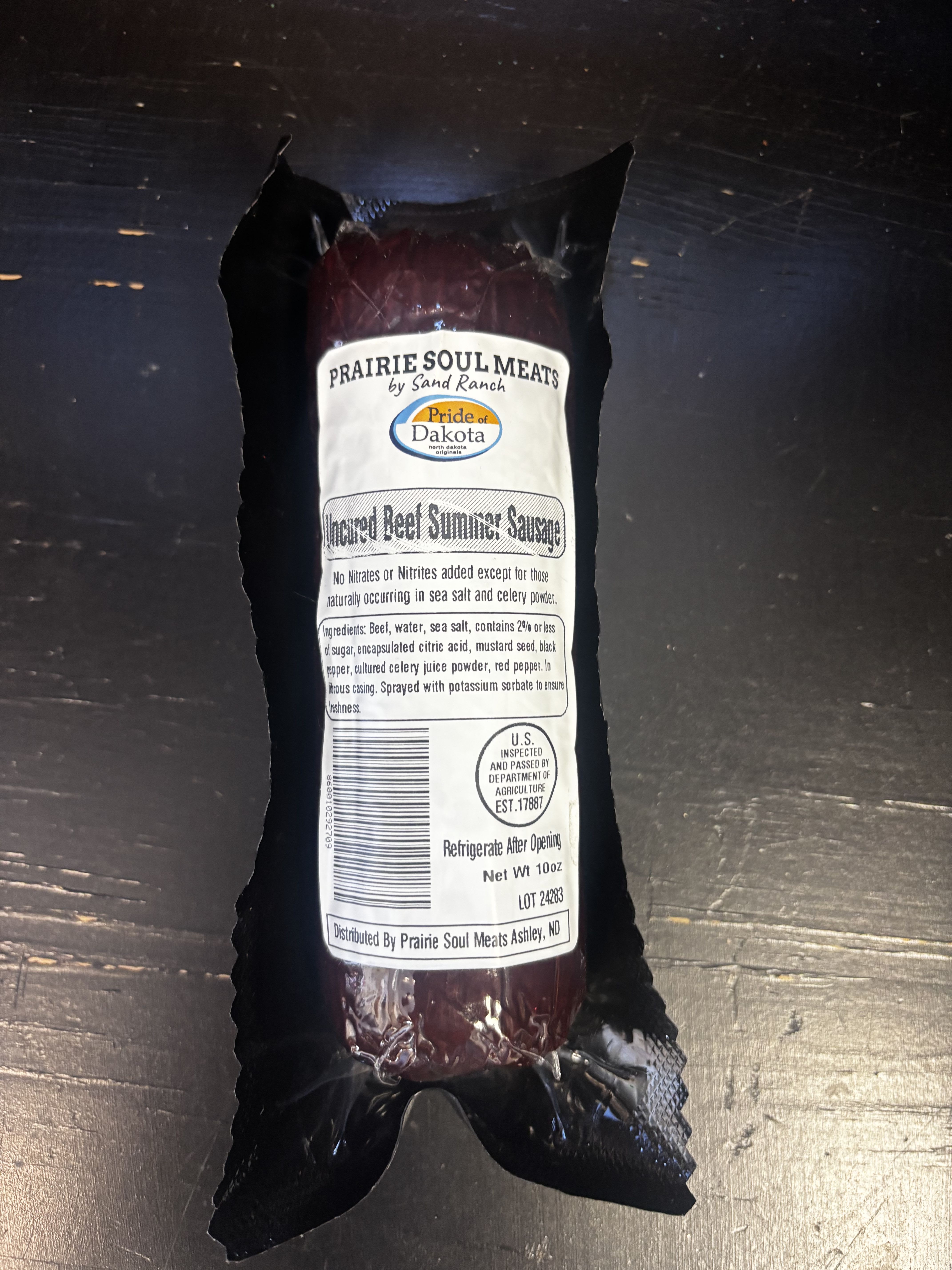 Packaged beef summer sausage in black wrapping