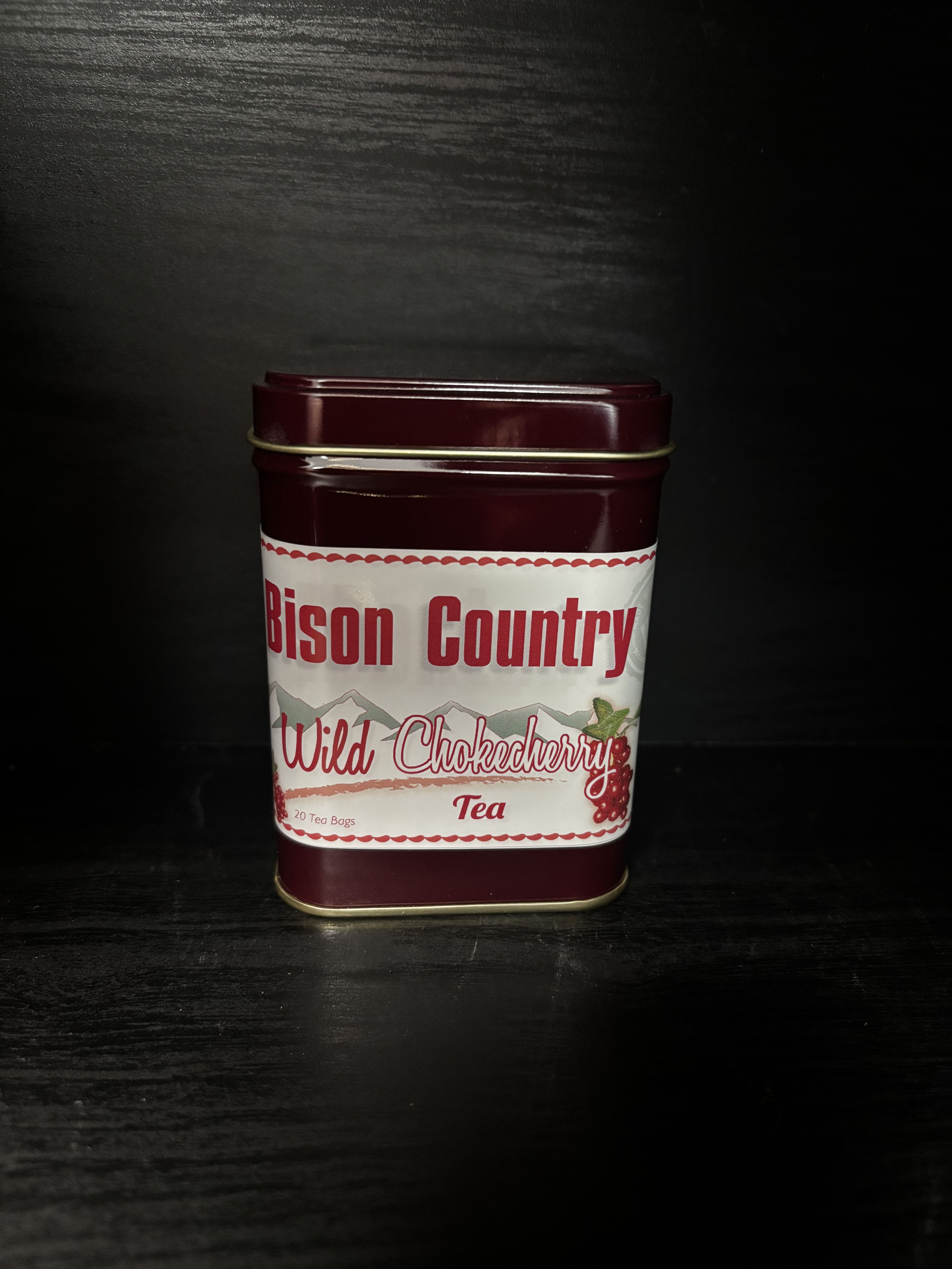 Maroon tin of Wild Chokecherry tea on a dark surface