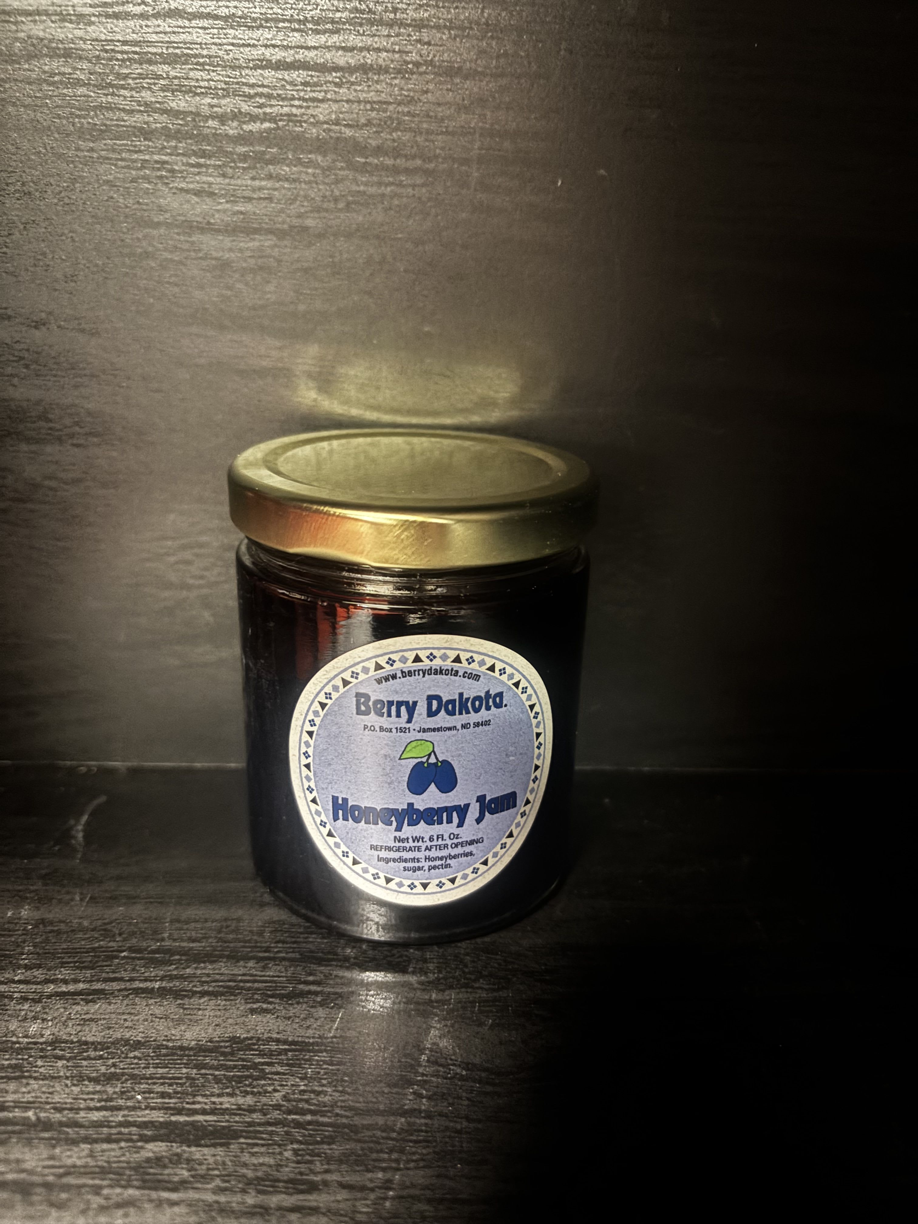 Jar of honeyberry jam with a gold lid