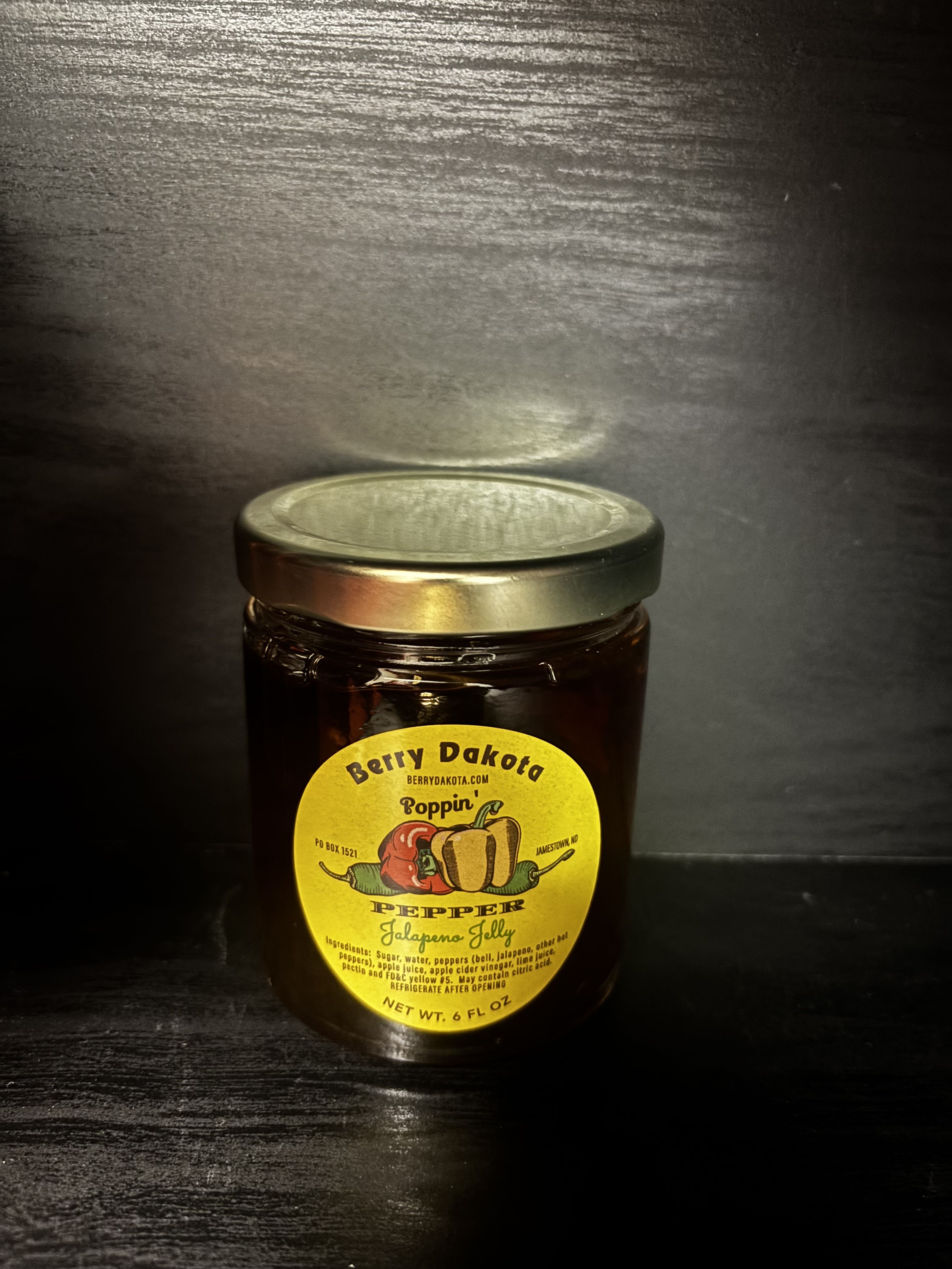 Jar of jalapeno jelly with a yellow label and metal lid