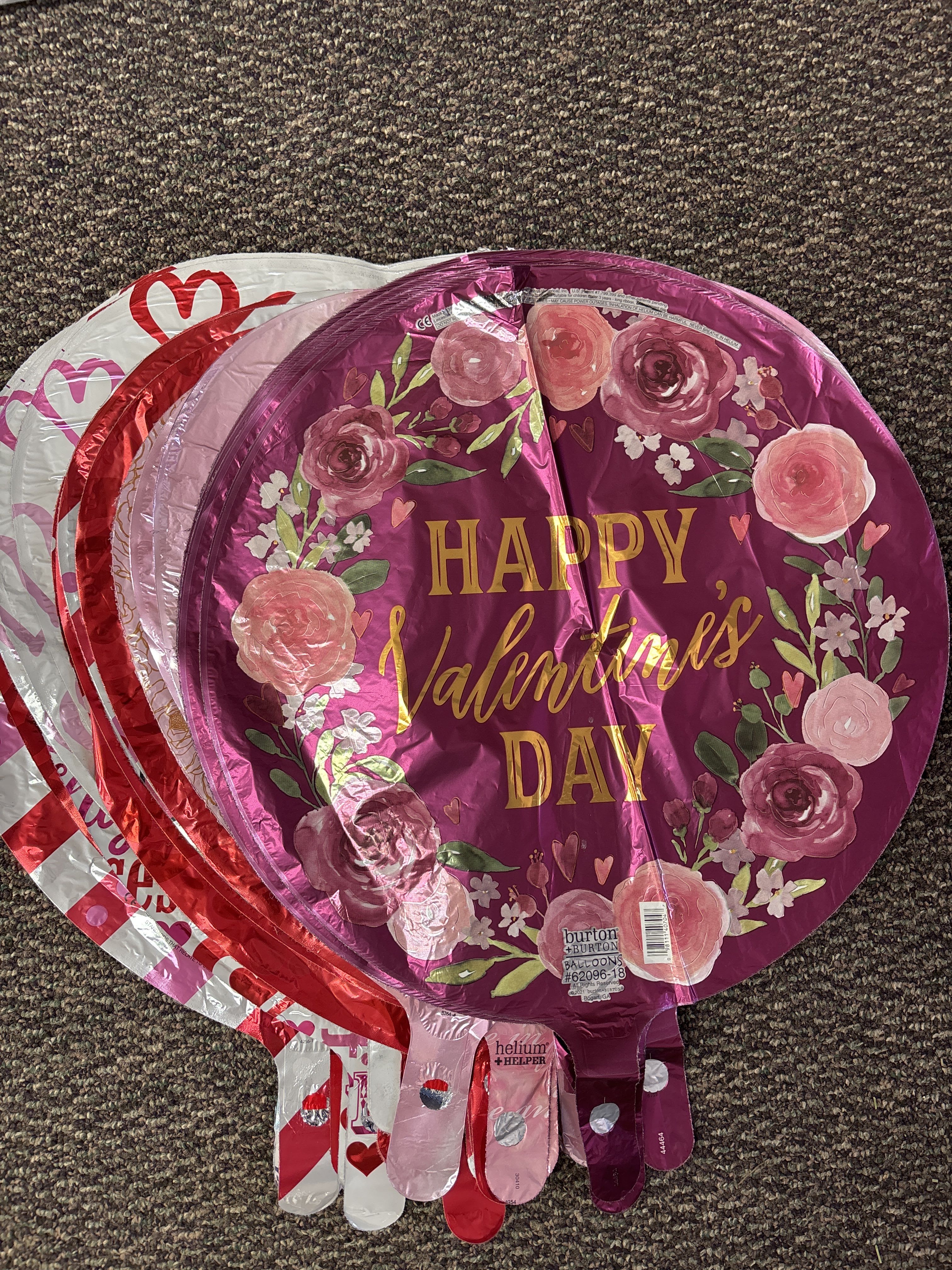Stack of round foil balloons with Valentine’s Day floral designs