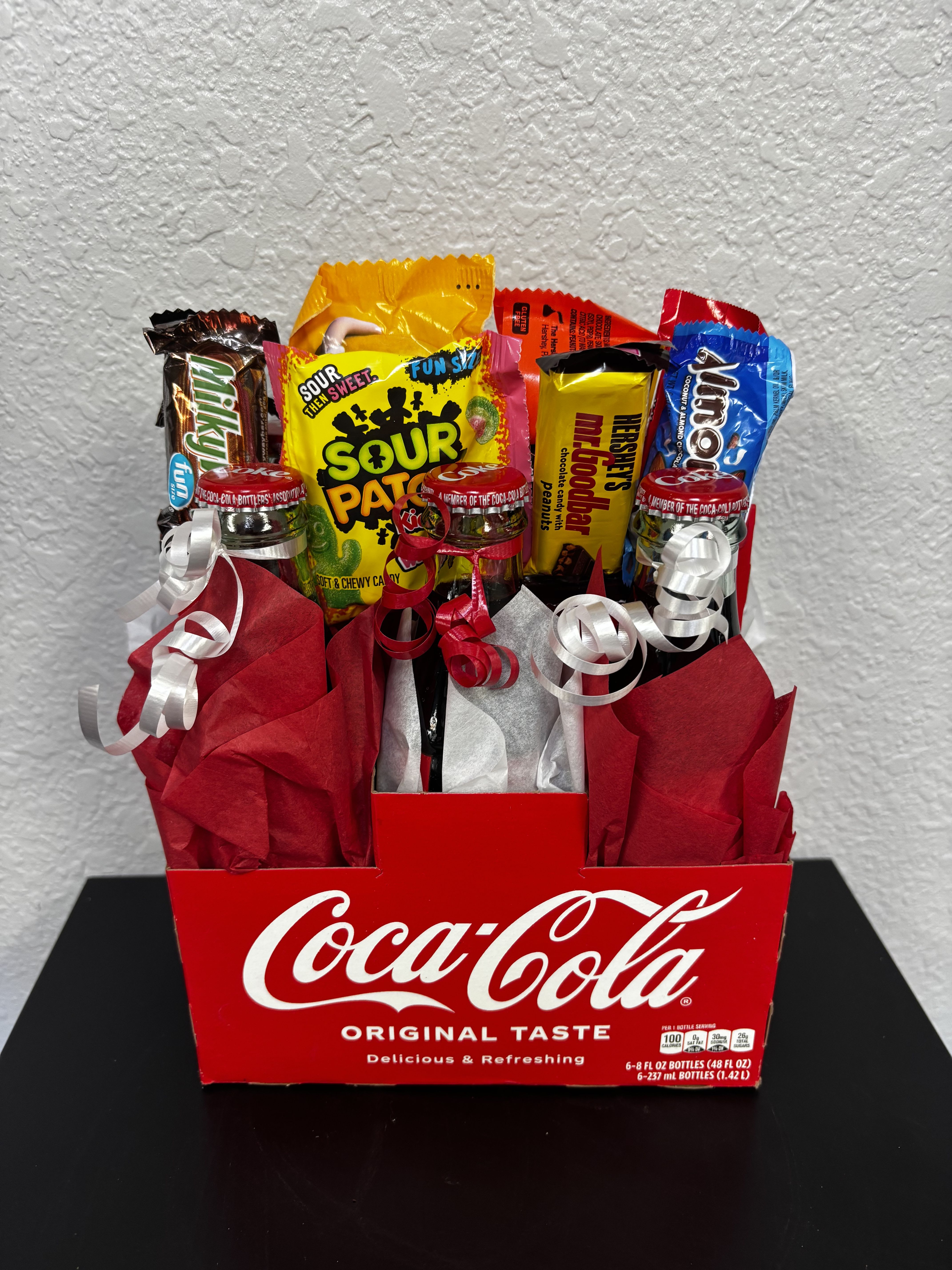 Coca-Cola gift box filled with assorted candy and ribbon curls